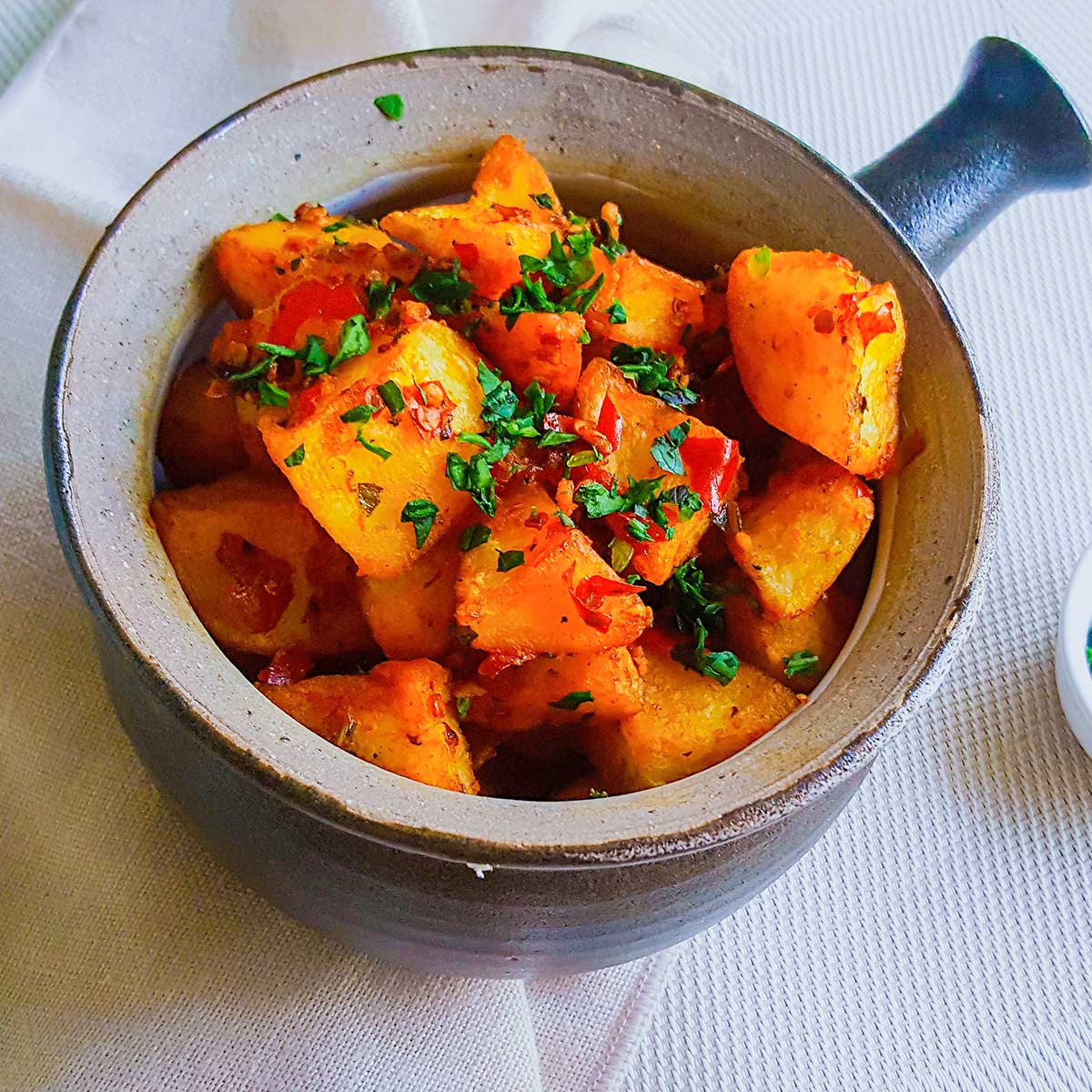 Batata Harrah served in a Bowl topped with cilantro and chilies
