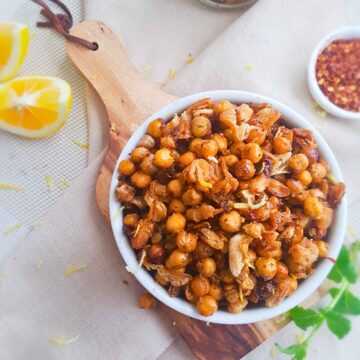 Roasted beans snack served in a white bowl placed on wooden board.