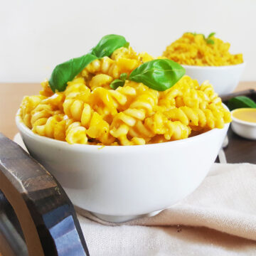 Vegan Pumpkin pasta served in a white bowl, garnished with basil leaves