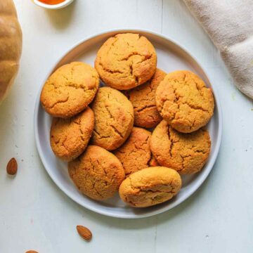 Pumpkin almond flour cookies stacked in a playe