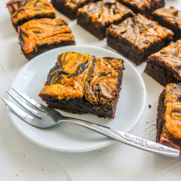 vegan pumpkin brownies on a white plate and silver fork