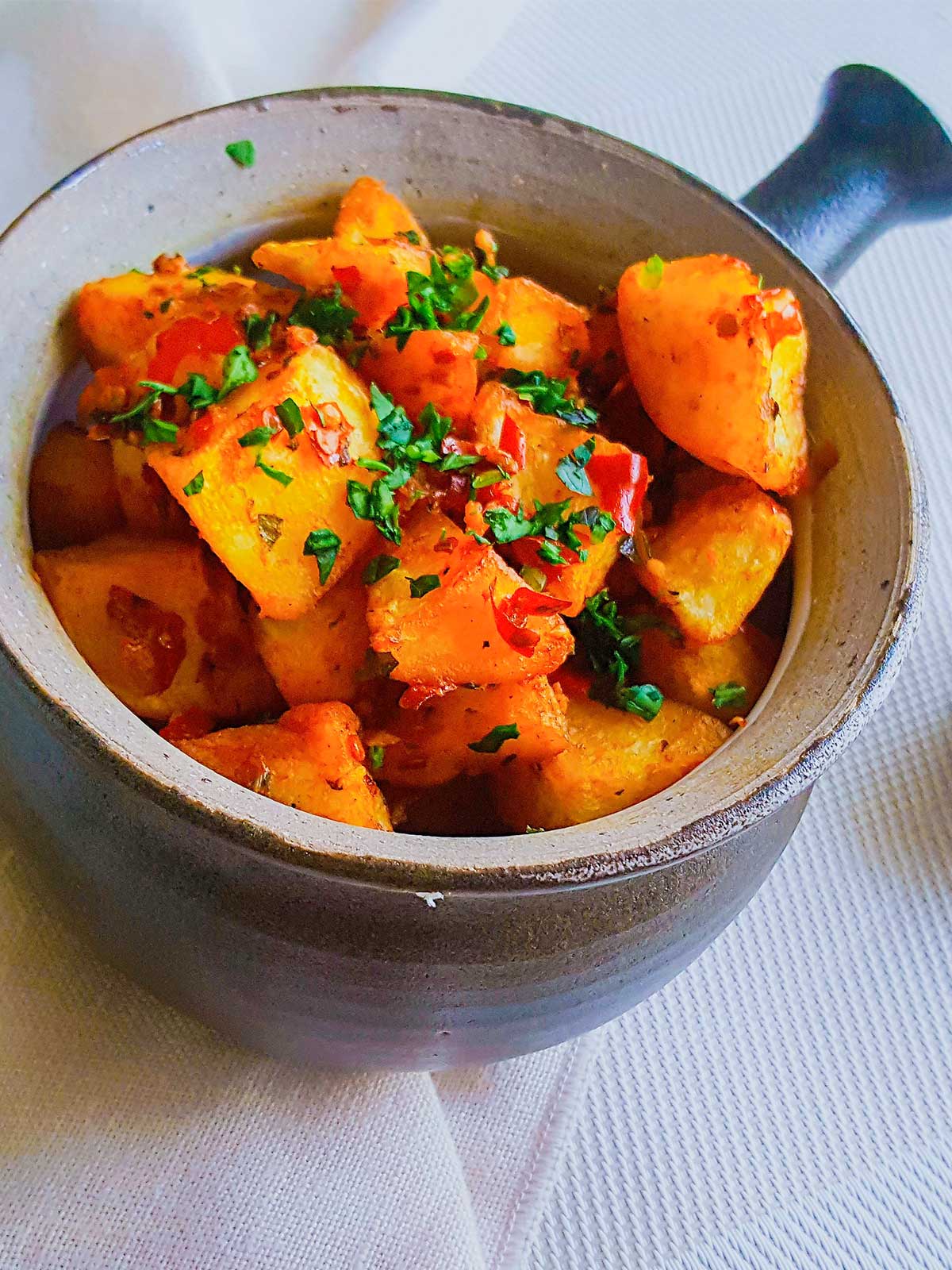 Batata Harrah served in a Bowl topped with cilantro and chilies