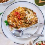 vegan biryani served in a plate with fork and spoon