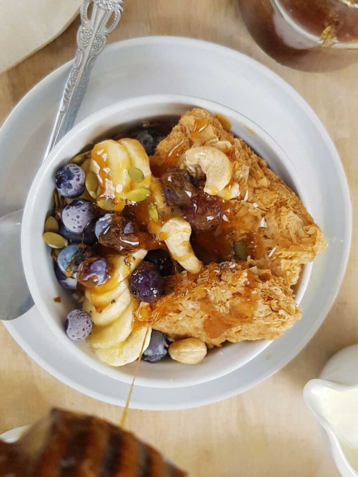 drizzling vegan honey on a bowl of cereal. 