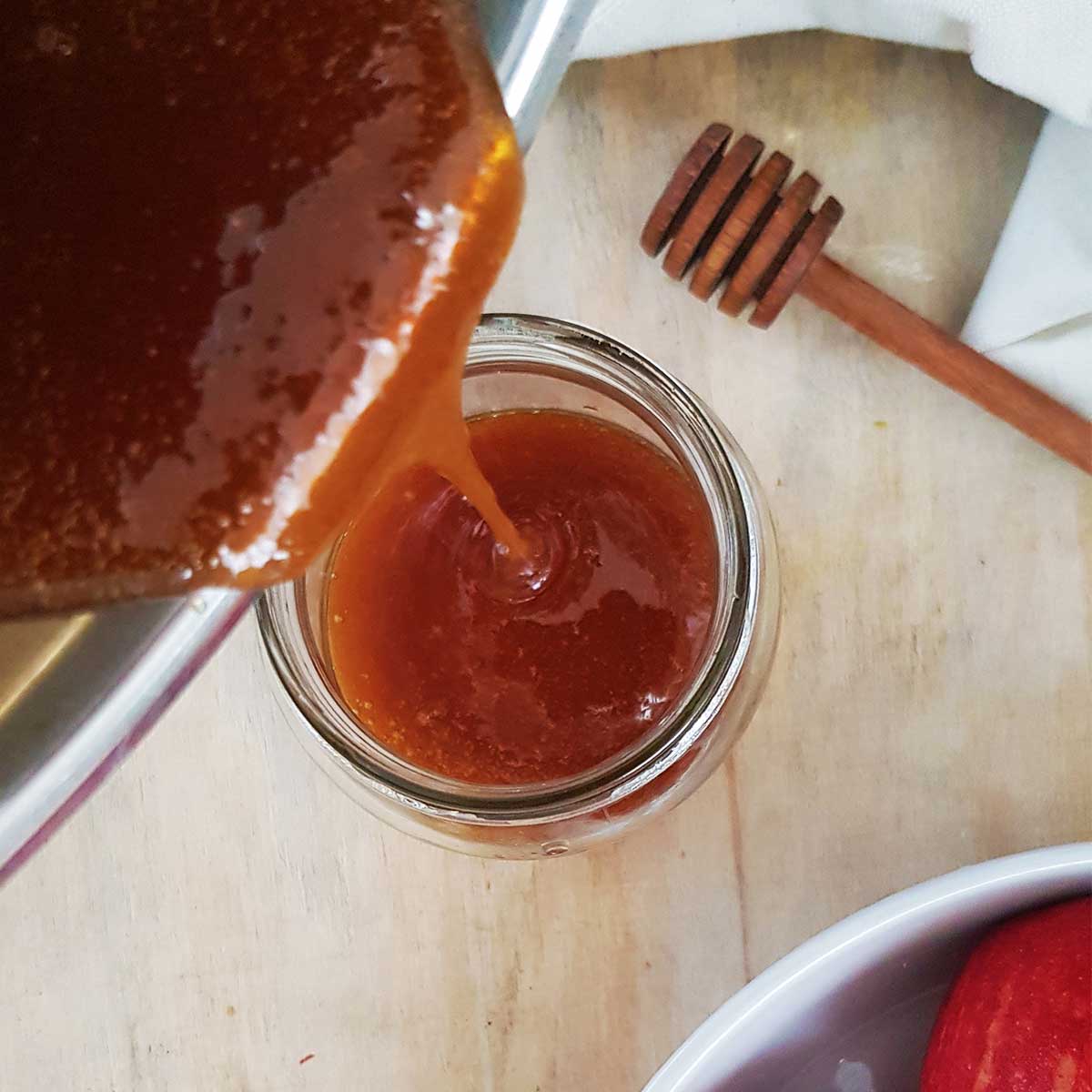 Pouring vegan honey into a glass jar