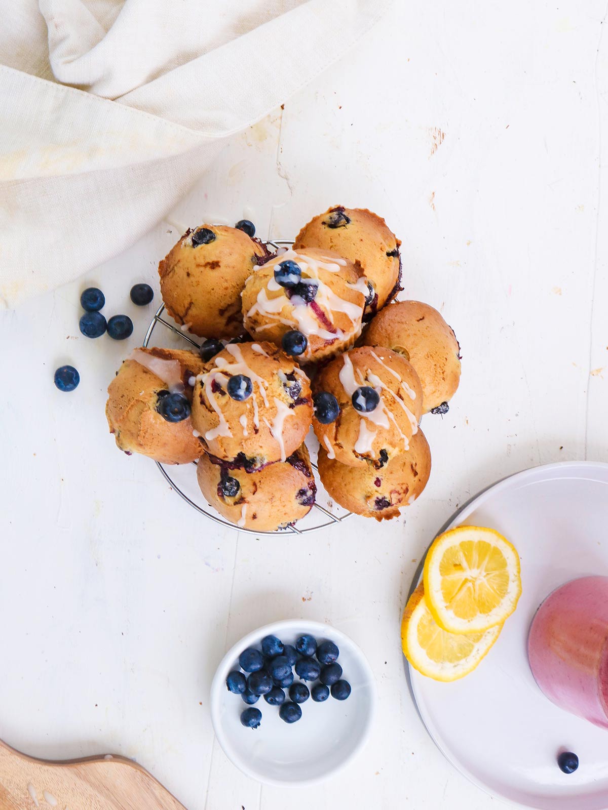 Vegan Blueberry lemon muffins topped with sugar lemon glaze. stack on a wire rack top view