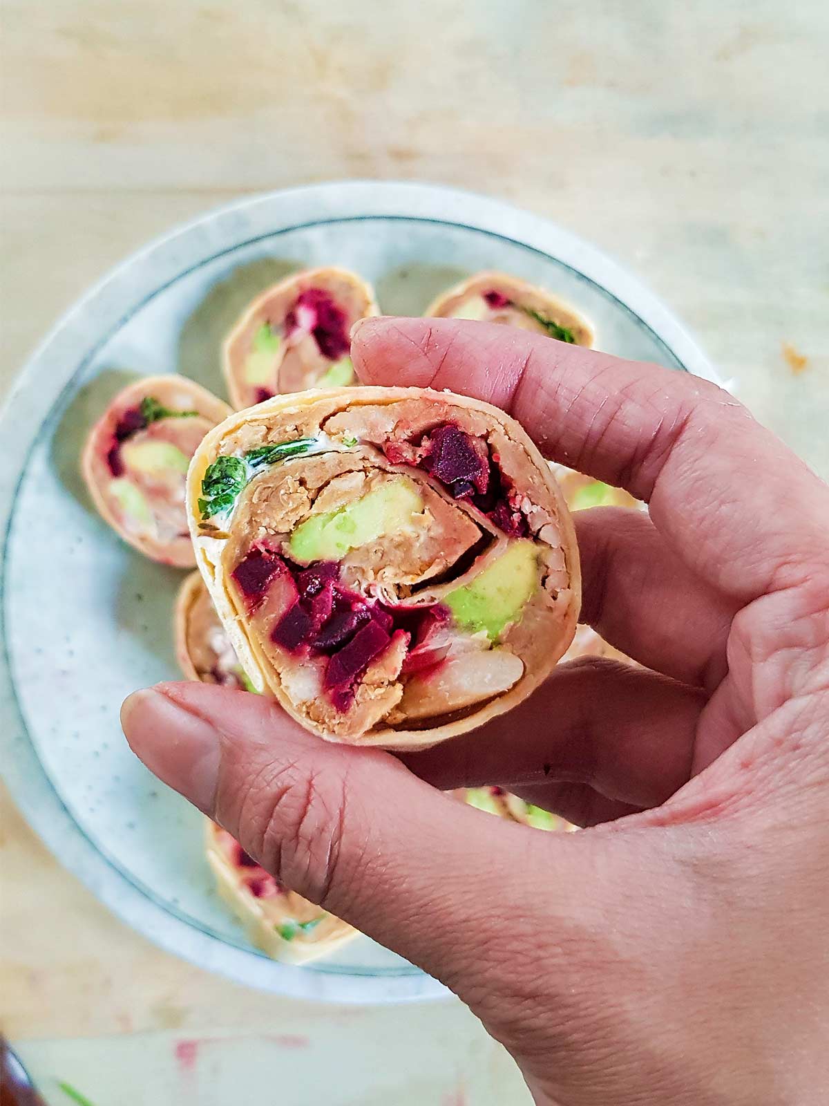 Holding Vegan pinwheels in hand