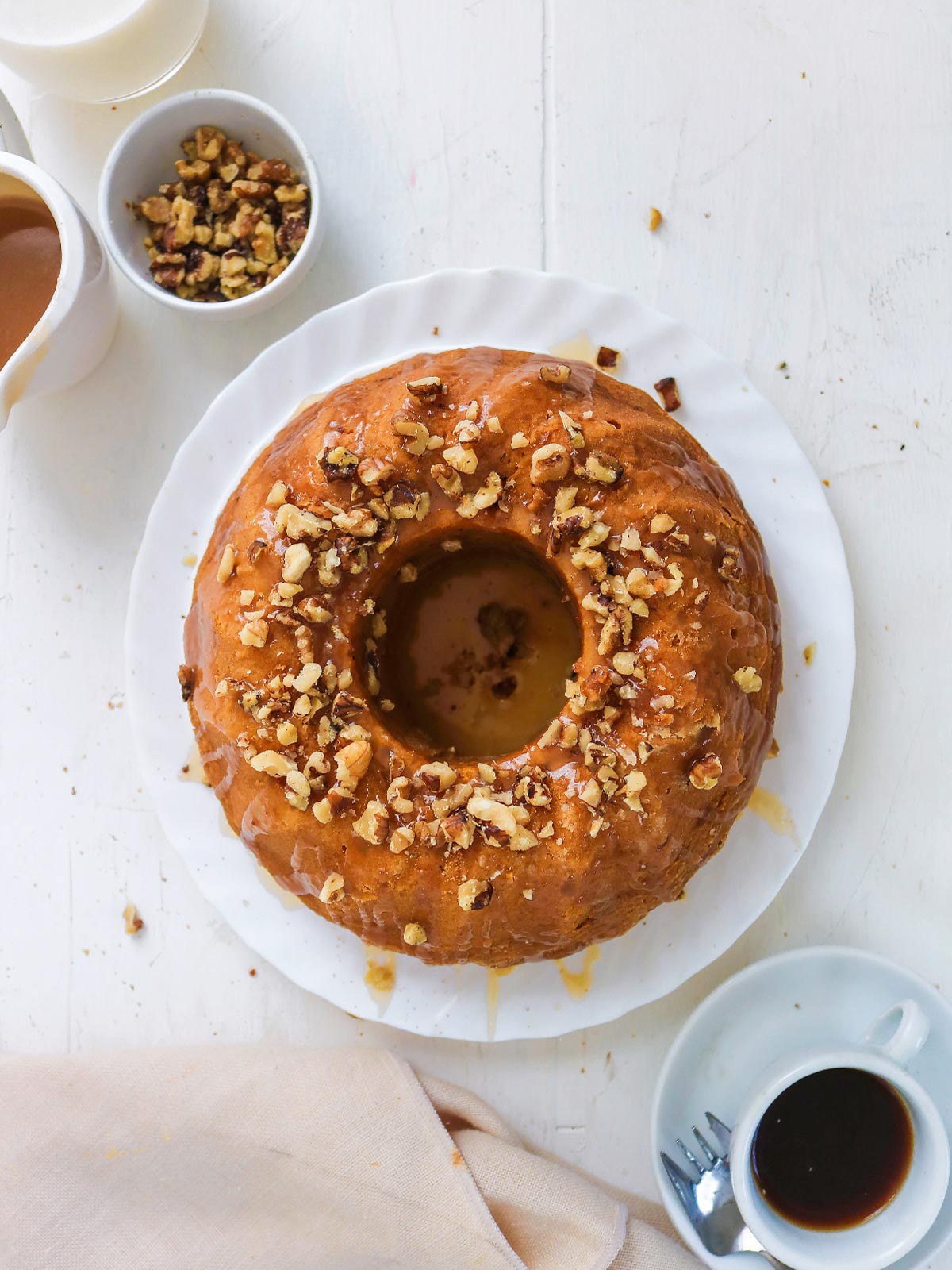 Vegan pumpkin bundt cake topped with caramel glaze and chopped walnuts