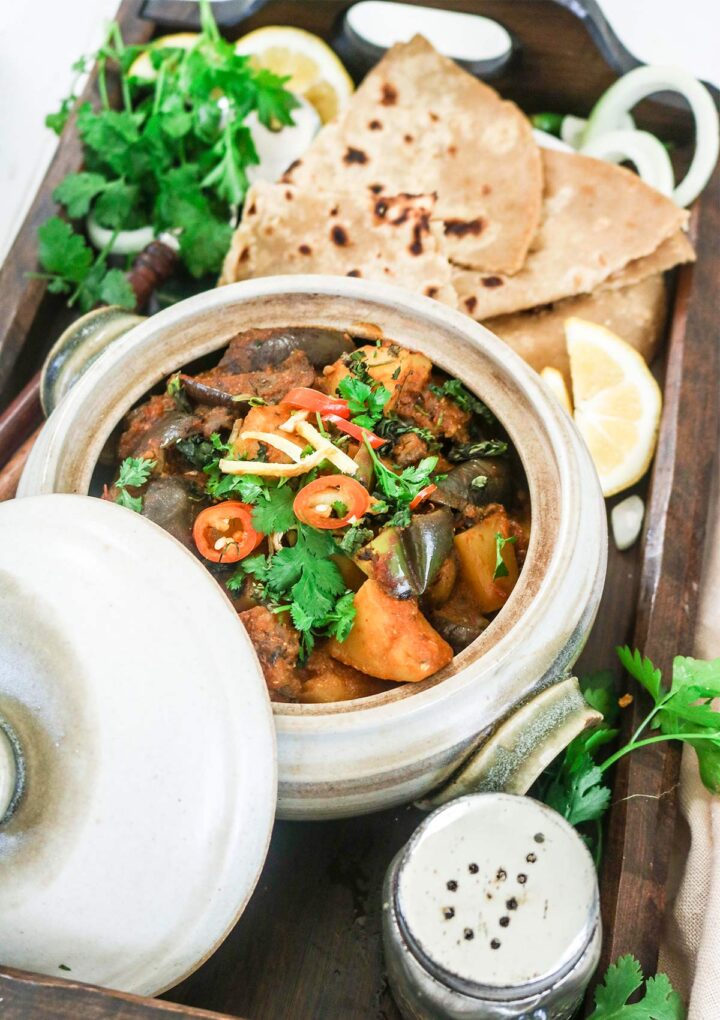 eggplant curry in a pot served over wooden tray