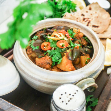 aloo baingan served in a ceramic bowl with paratha