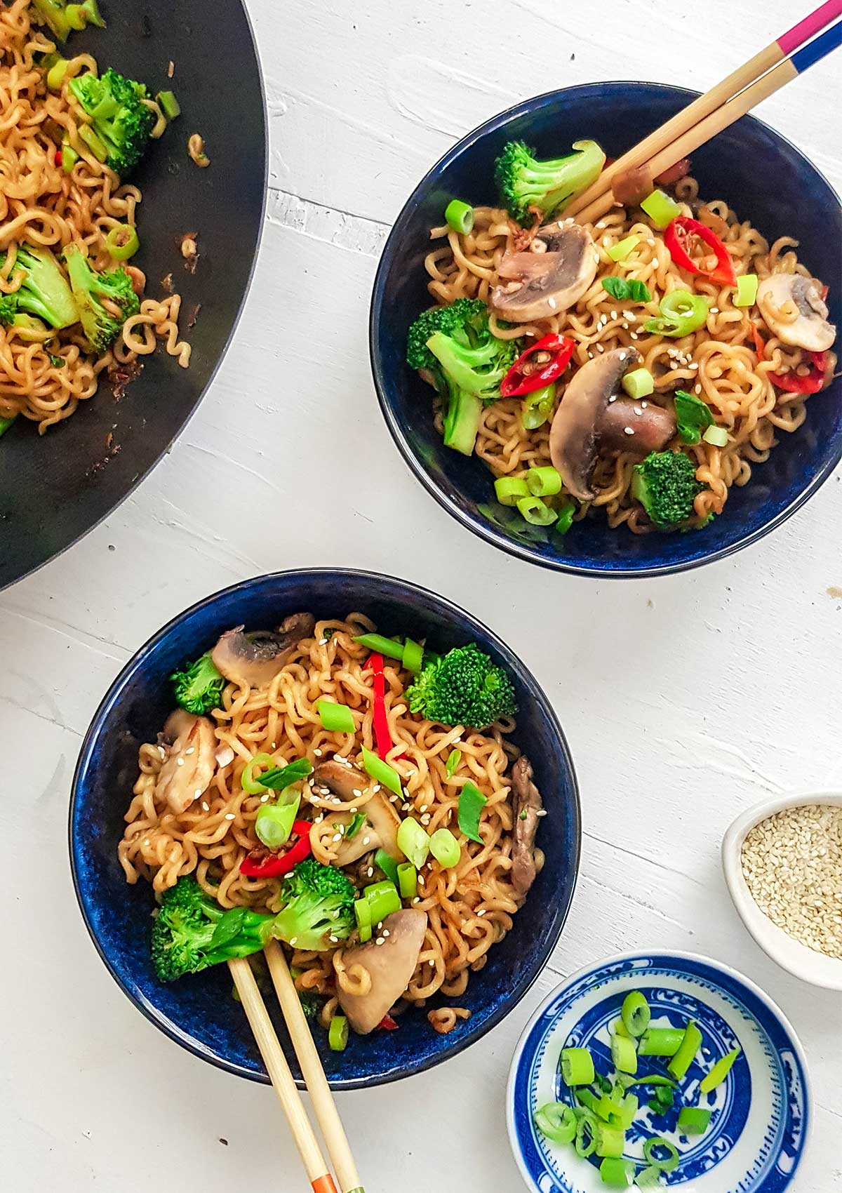 Ramen served in two blue bowls with chop sticks