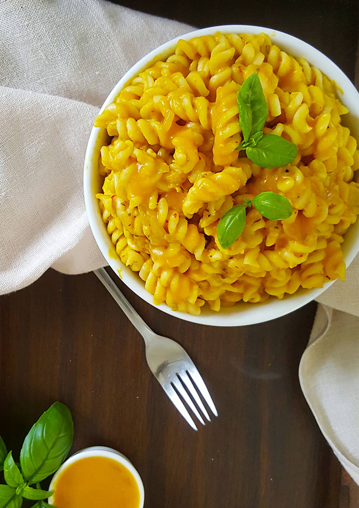 Pumpkin pasta served in a white bowl with a fork