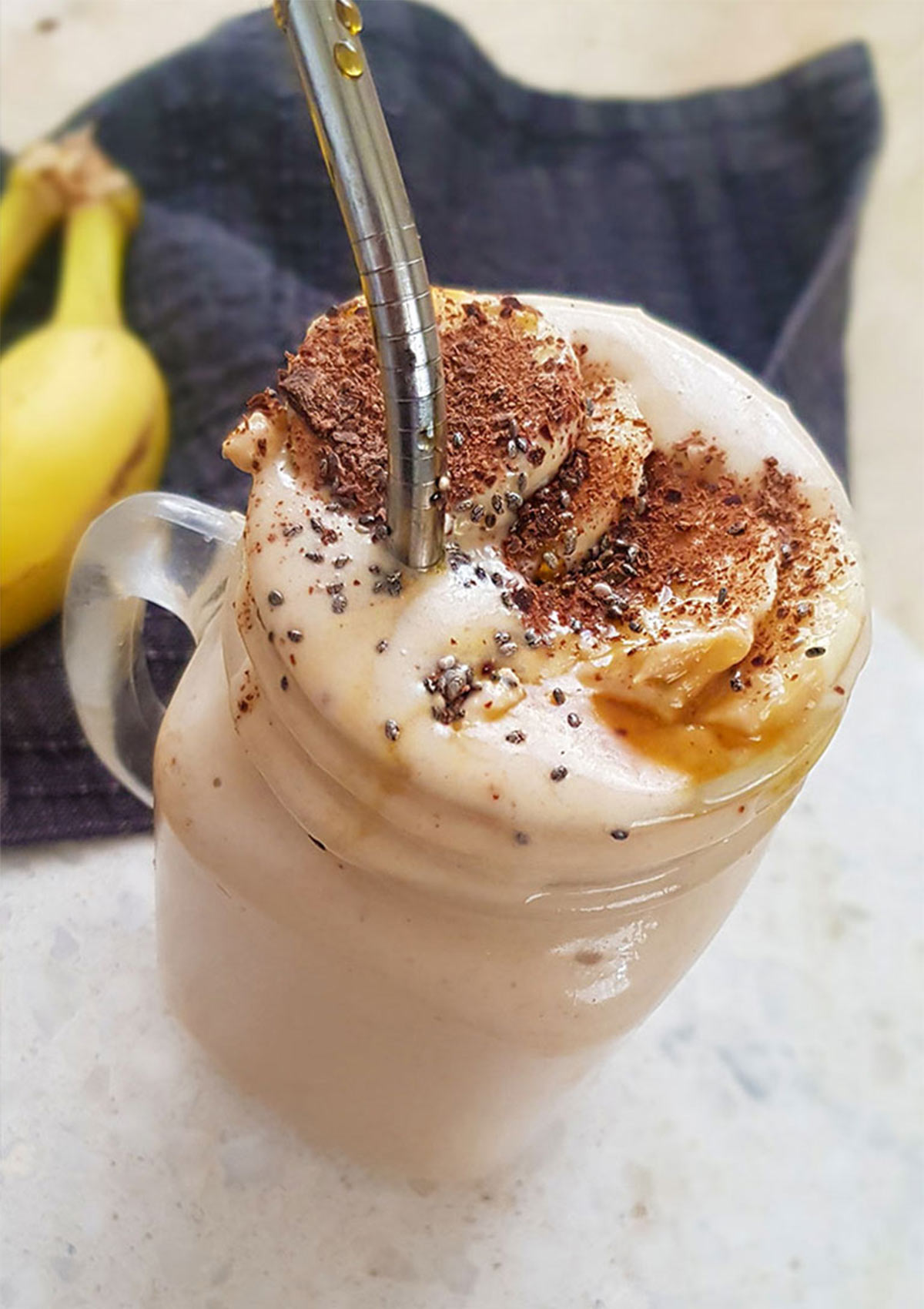 Banana peanut butter smoothie topped with banana slices and chia seeds.
