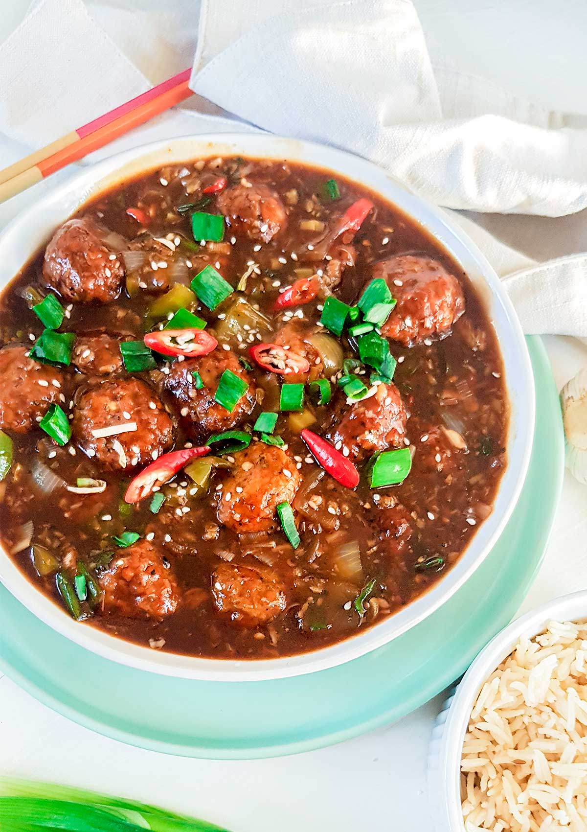 Veg Manchurian balls in thick gravy, 
garnished with spring onions and chilies.