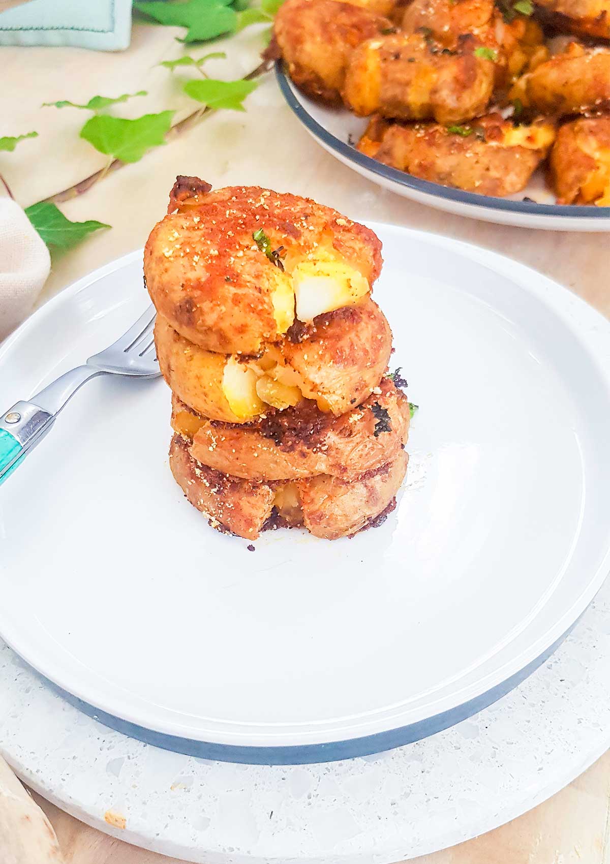 smashed potatoes stack on a plate with fork