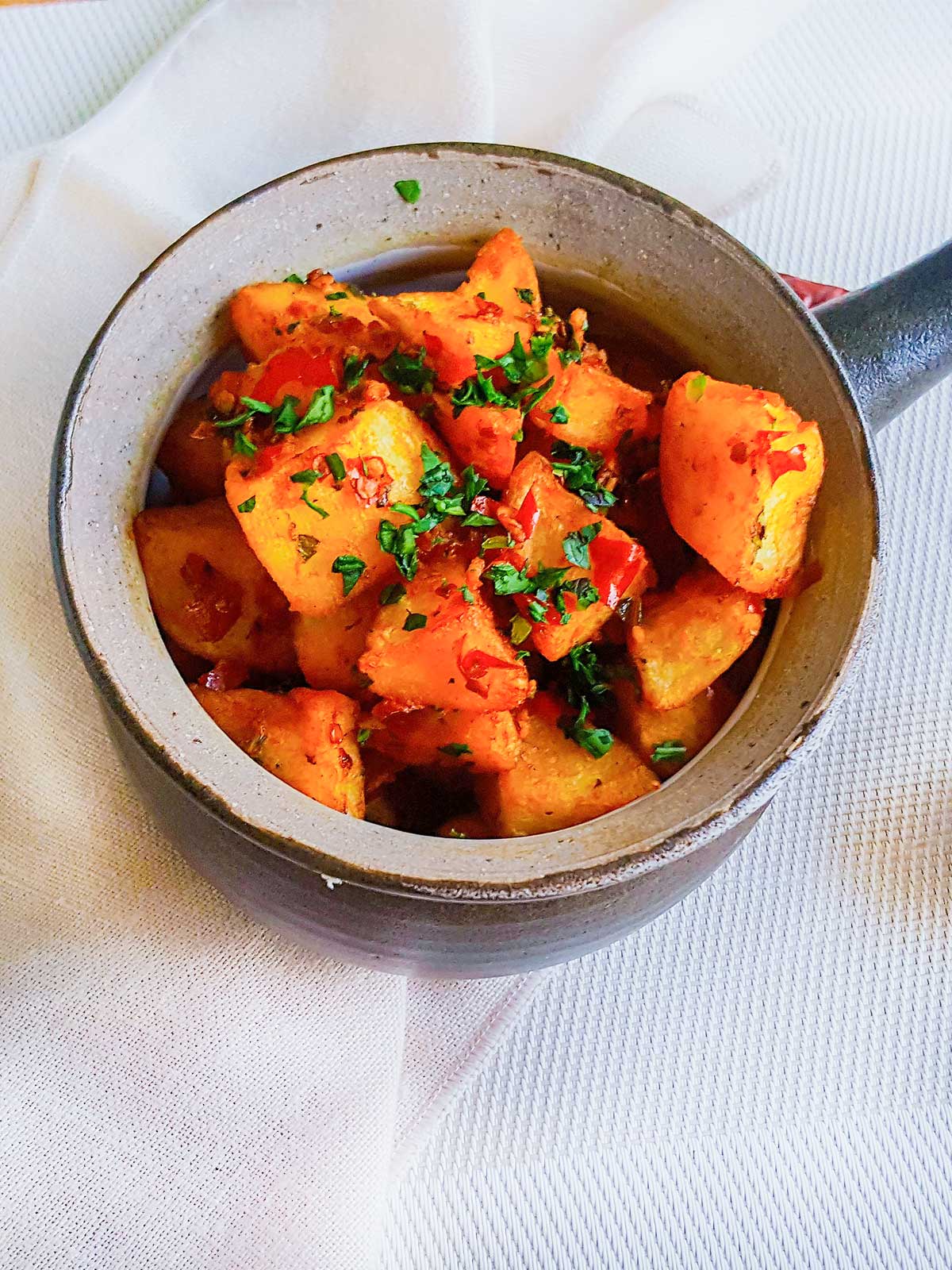 batata haara served in a deep round bowl with handle