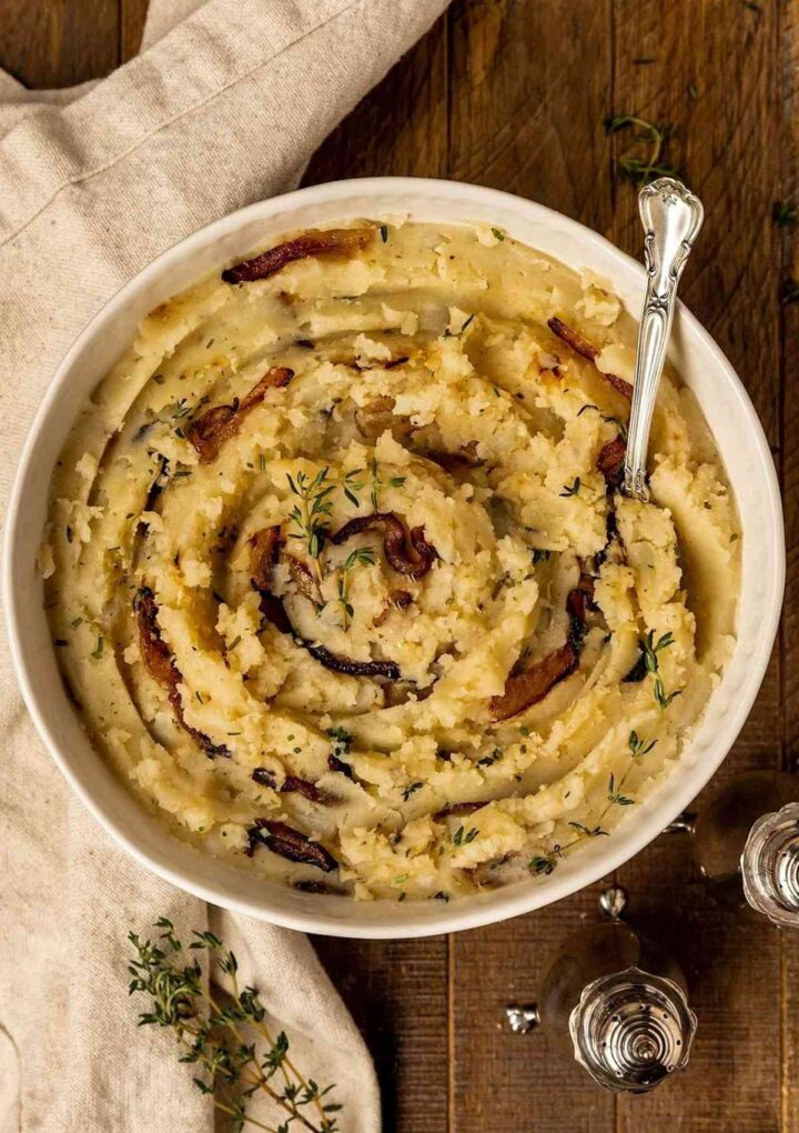 potato mash in a white bowl and silver spoon