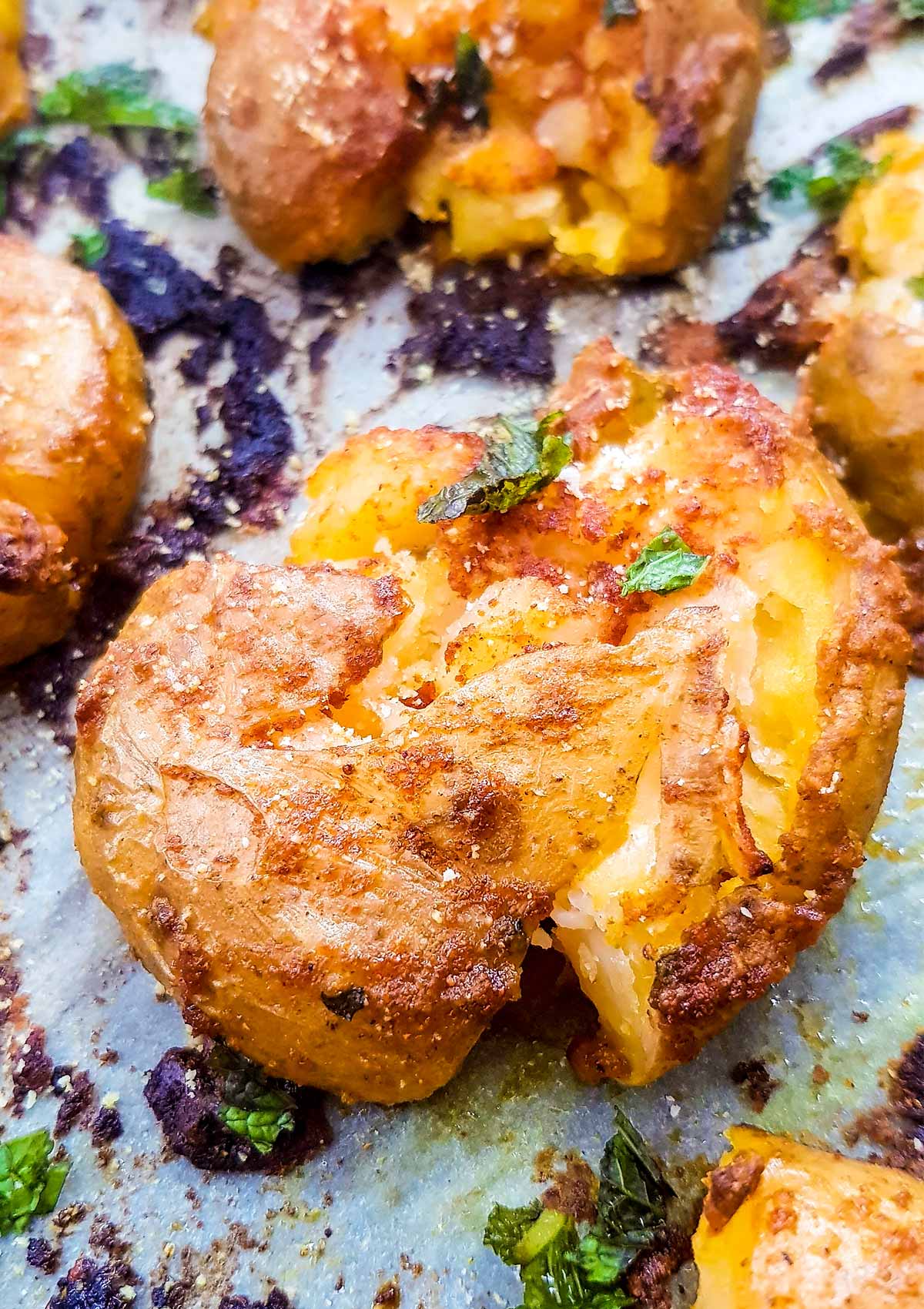 closeup of crispy smashed potatoes in roasting tray