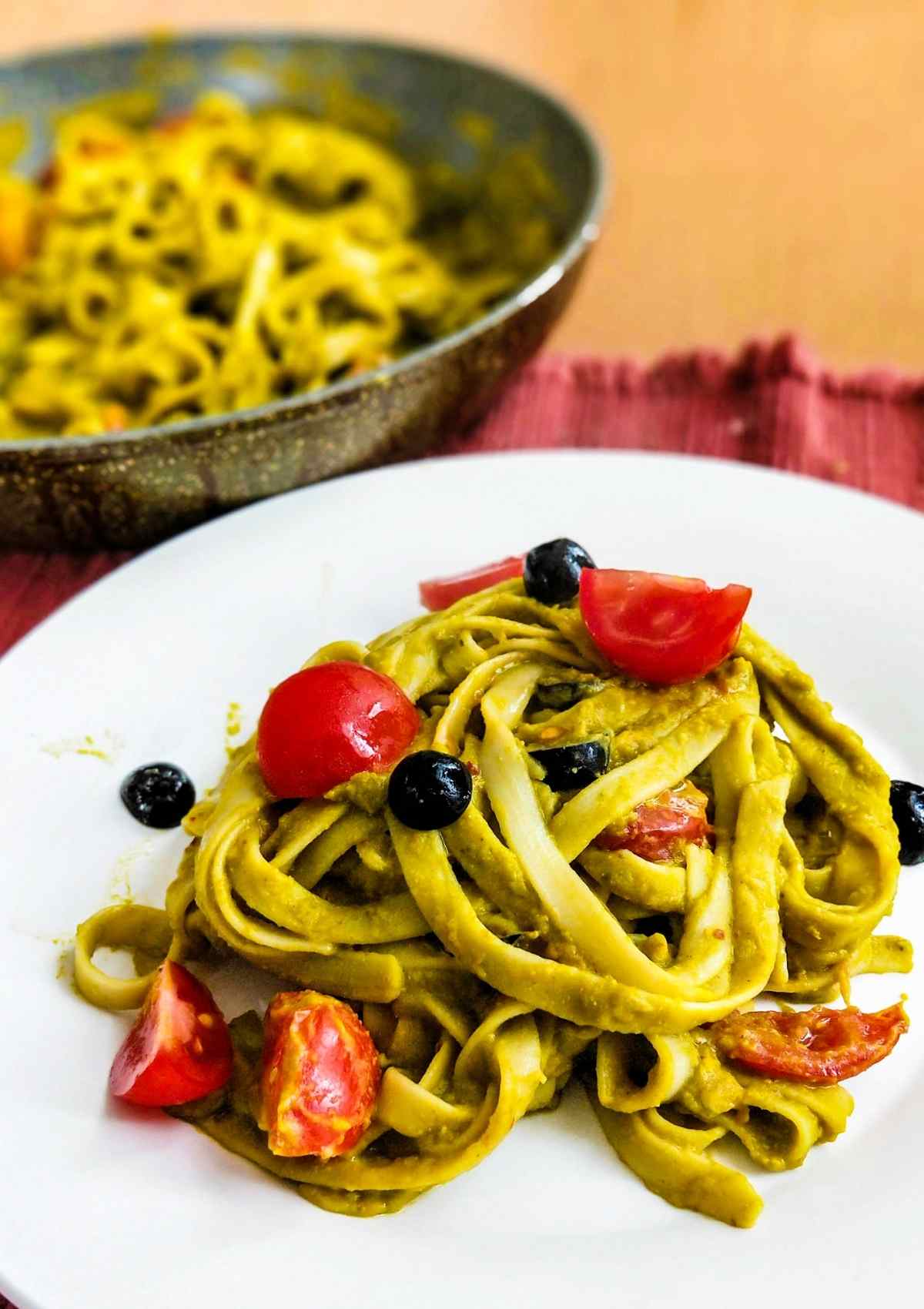 green color vegan spinach pasta served in a white plate