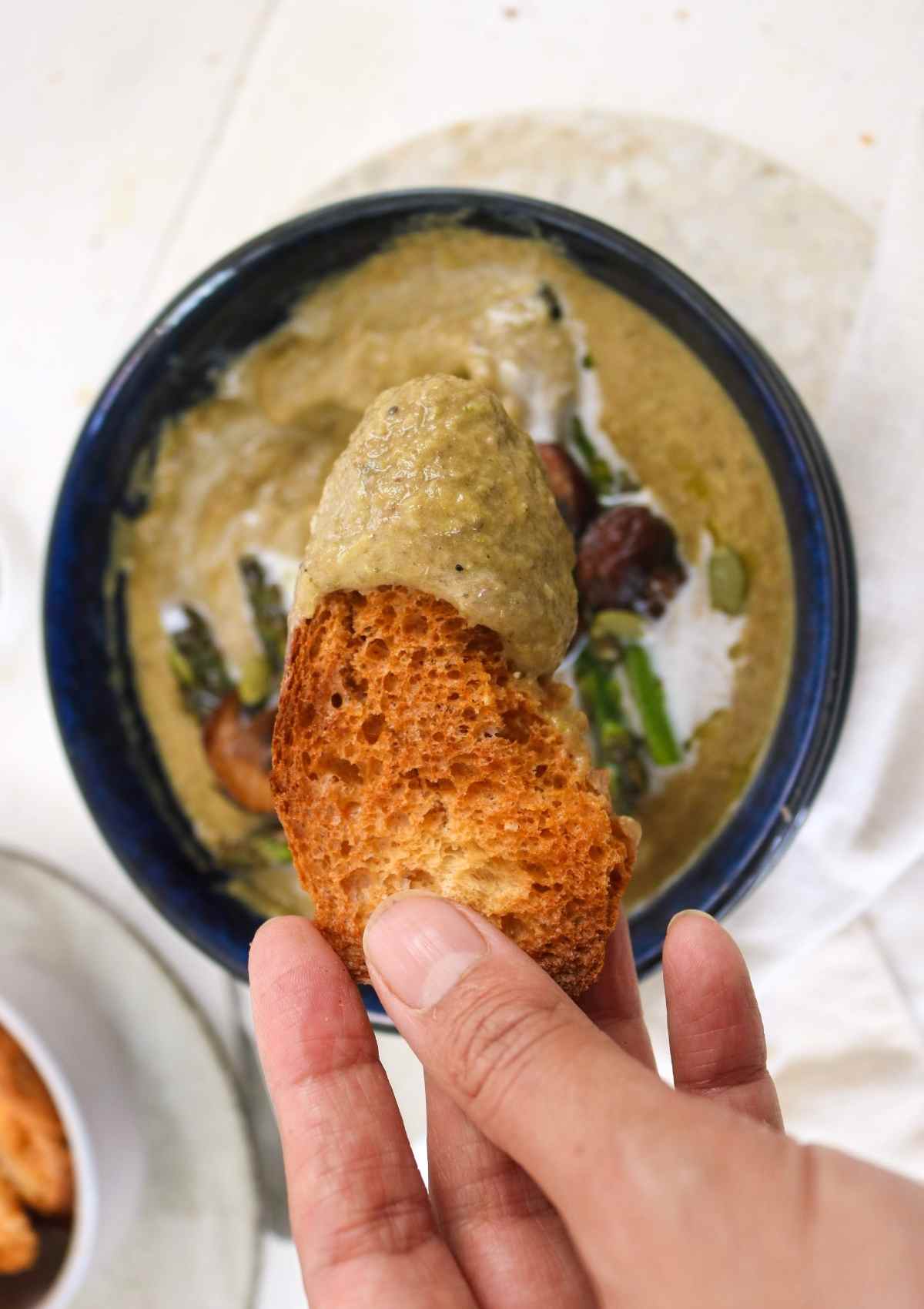 piece of rustic bread and mushroom asparagus soup