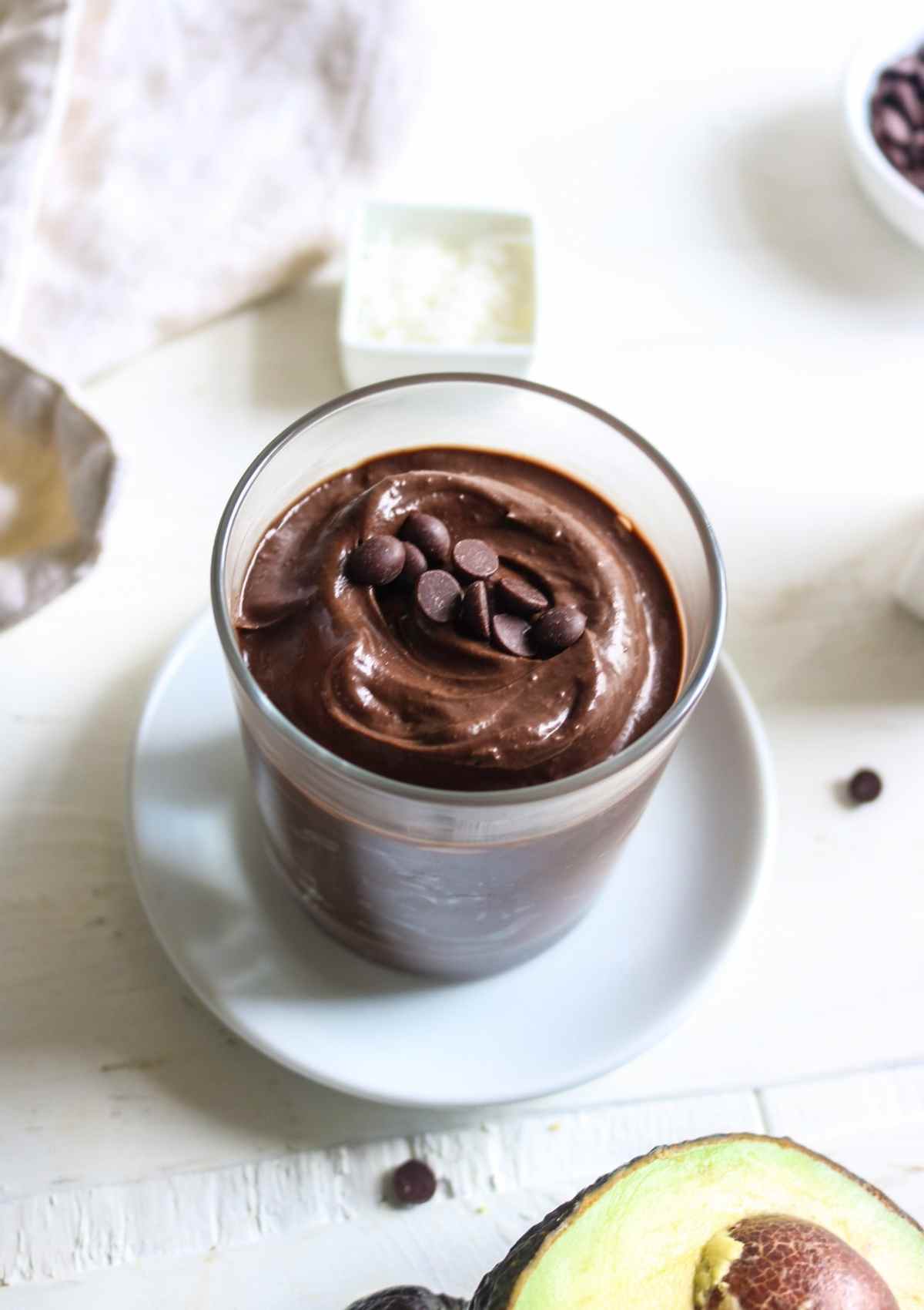 vegan chocolate mousse made with avocado served in a glass and chocolate chips on top