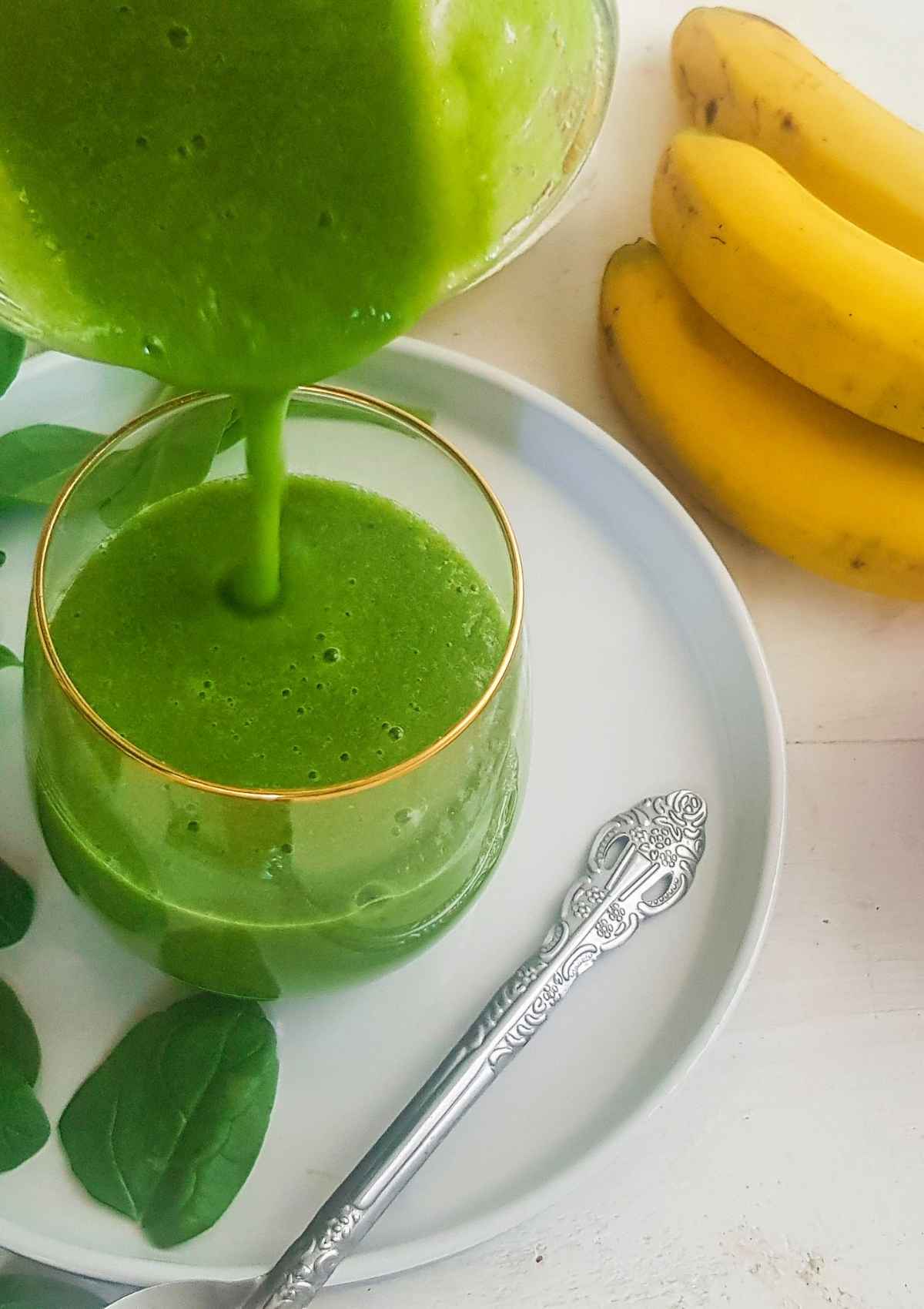 Pouring green color smoothie in a glass