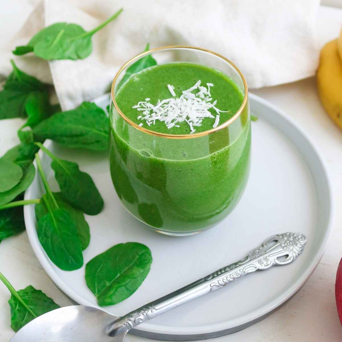 Green color apple banana spinach smoothie in a glass