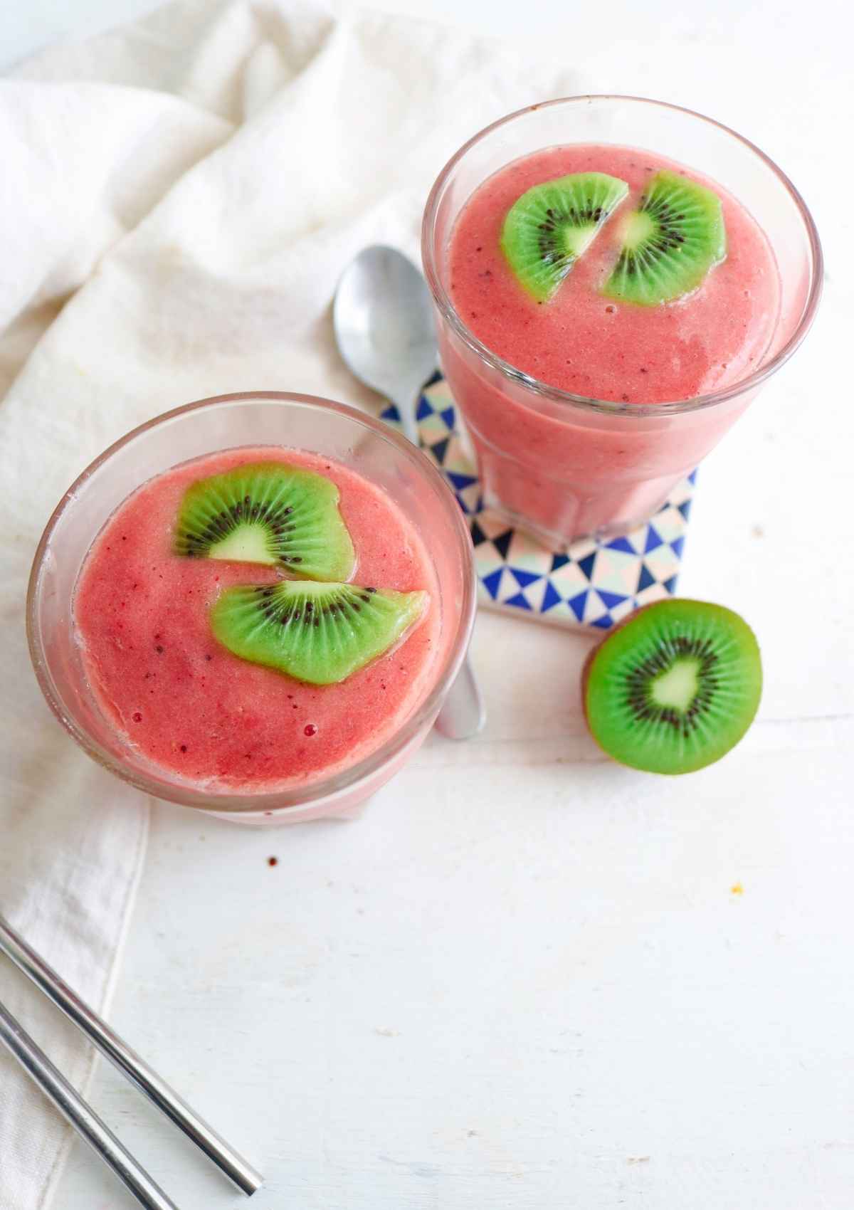 Strawberry Kiwi Pineapple Smoothie served in two glassed topped with kiwi slices