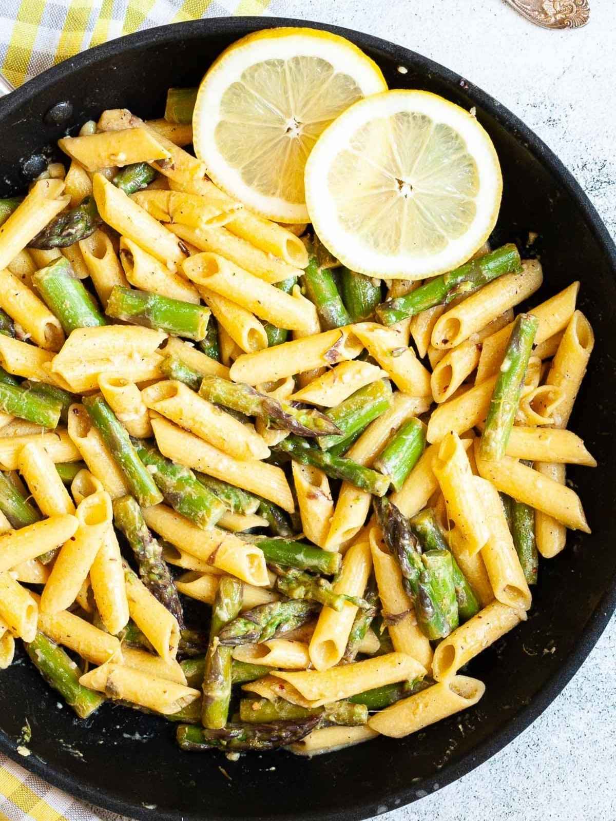 Pasta and asparagus cooked in a wok.