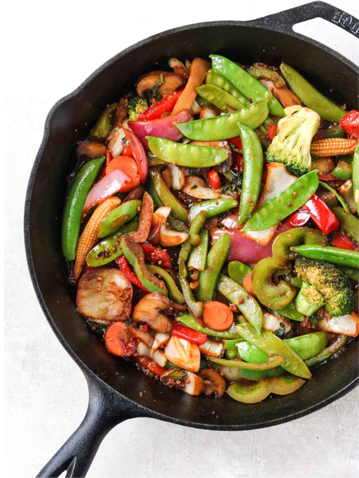 Stir fry vegetables in a black wok.