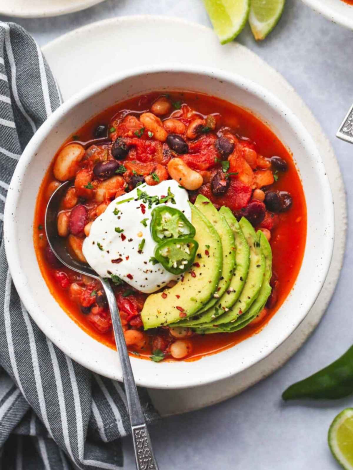 white pot filled with chili toped with avocado slices