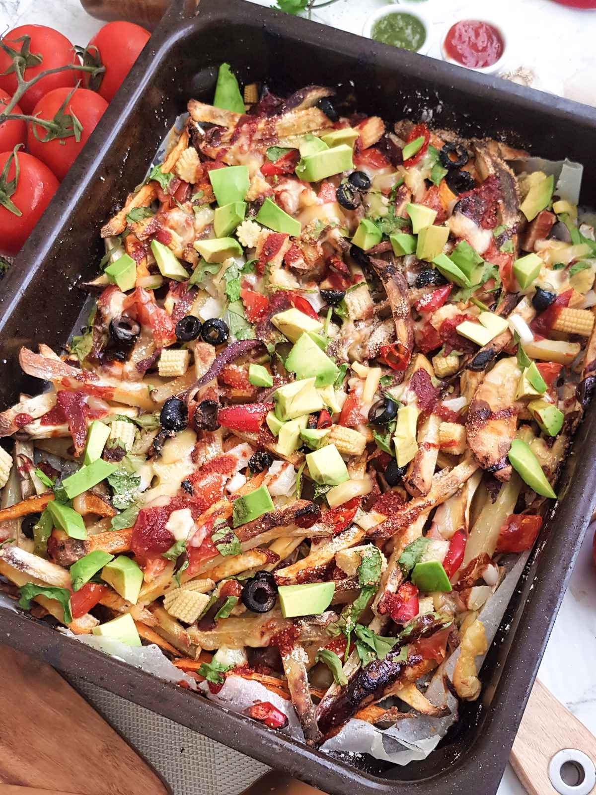 colorful vegan loaded fries in a brown color baking tray.