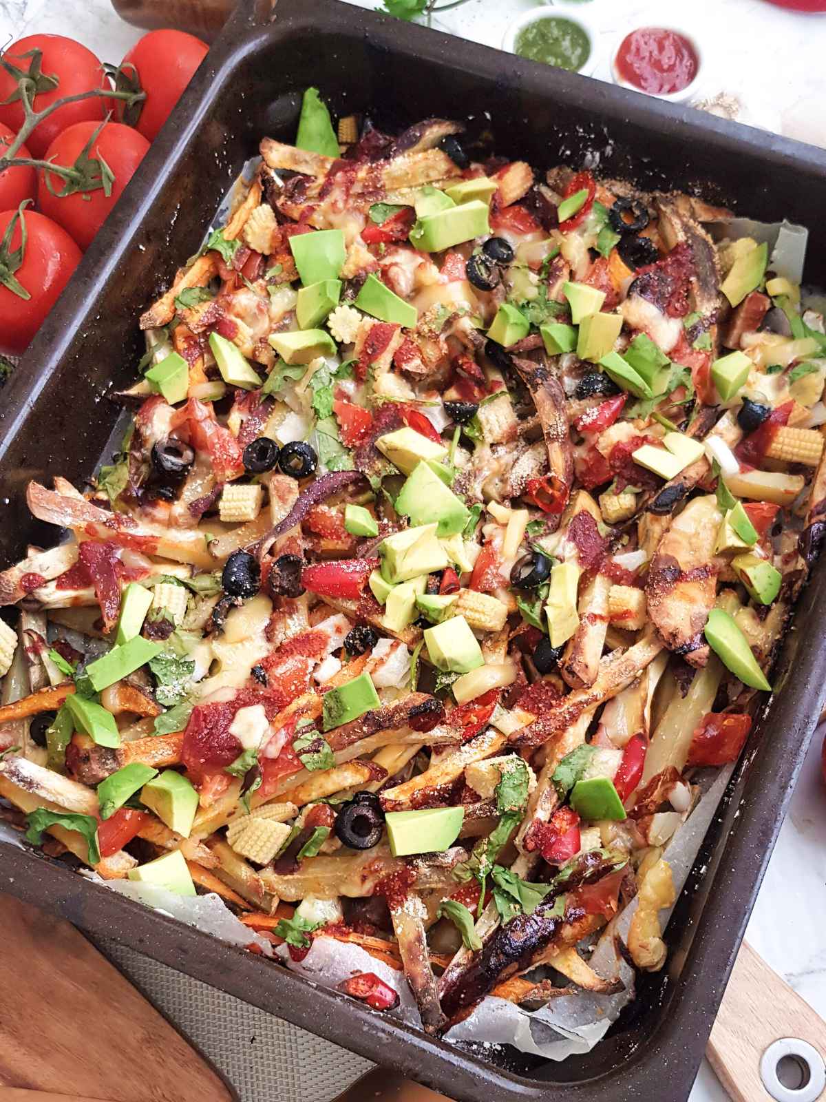 colorful vegan loaded fries in a brown color baking tray. 