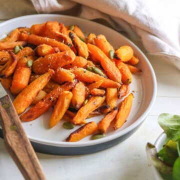 orange color baby carrots served in a white plate.