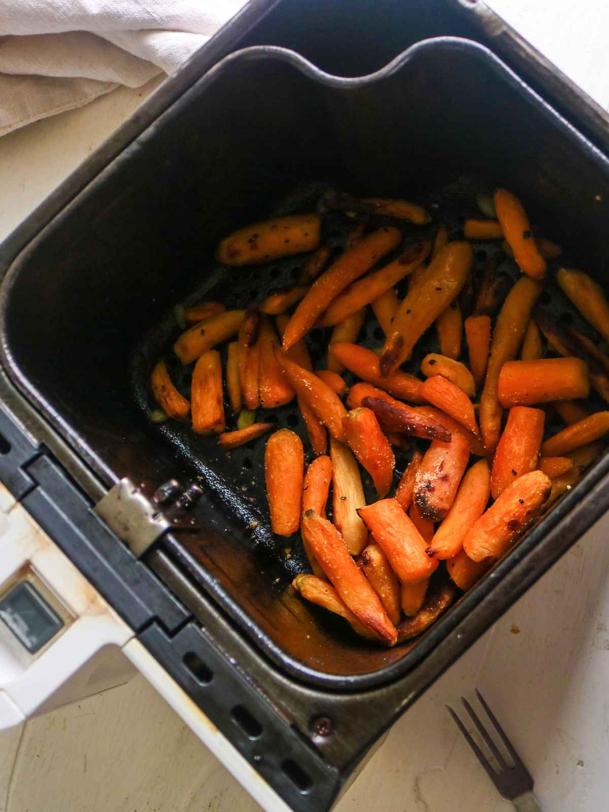 Baby carrots placed in air fryer basket.