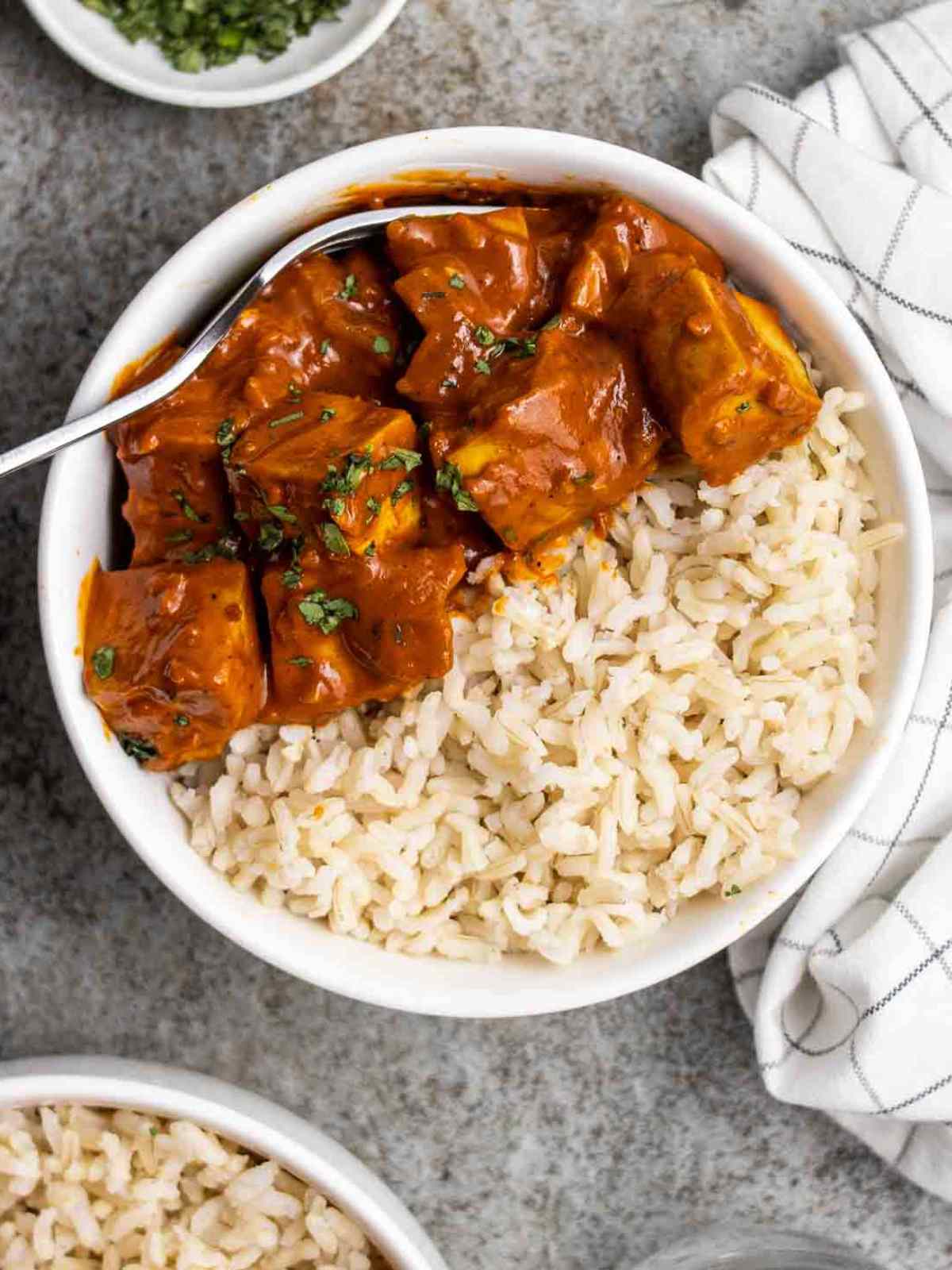 Creamy orange color tofu curry served on a bed of white rice.