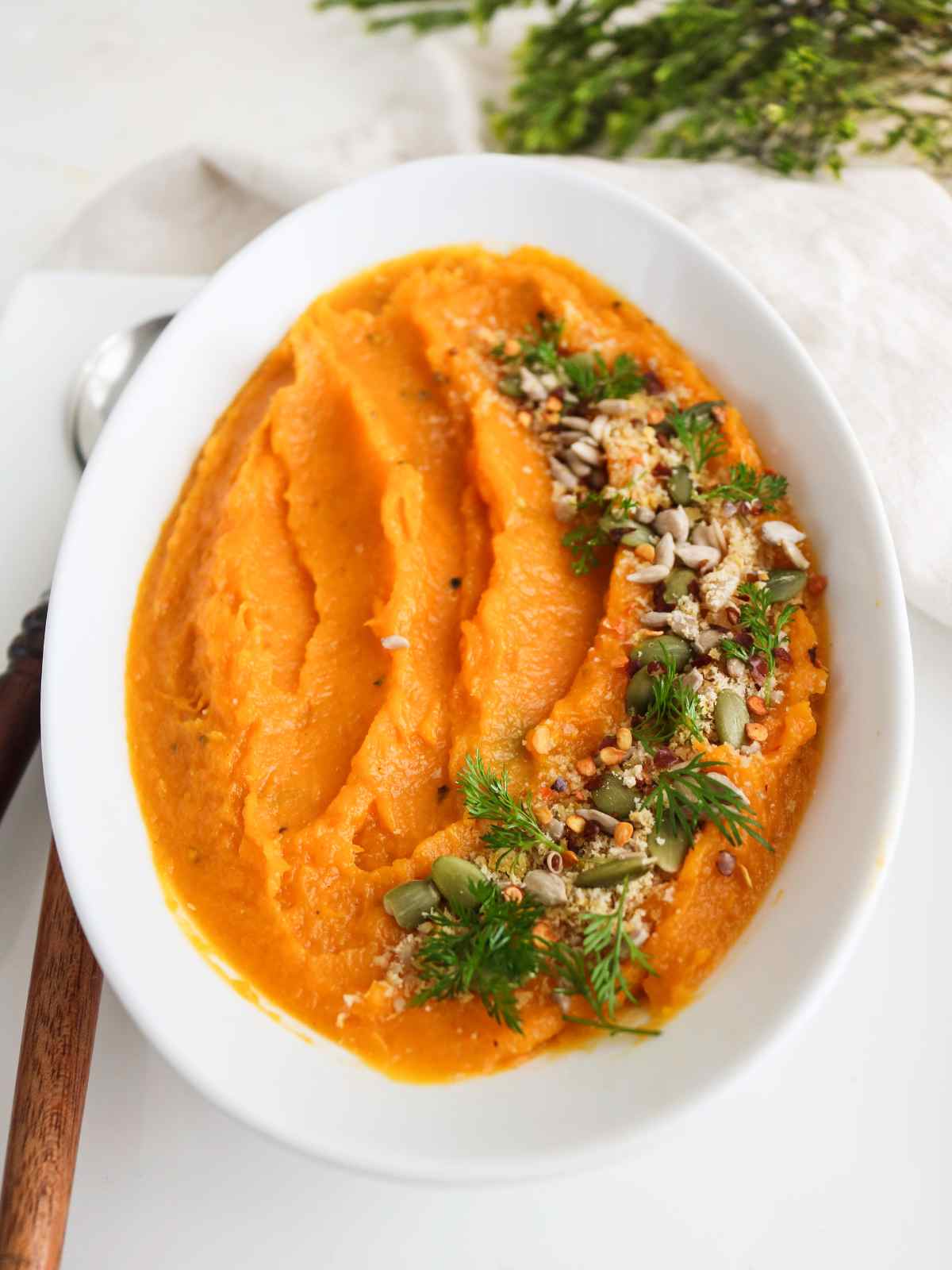 Mashed butternut squash garnished and served in a dish.
