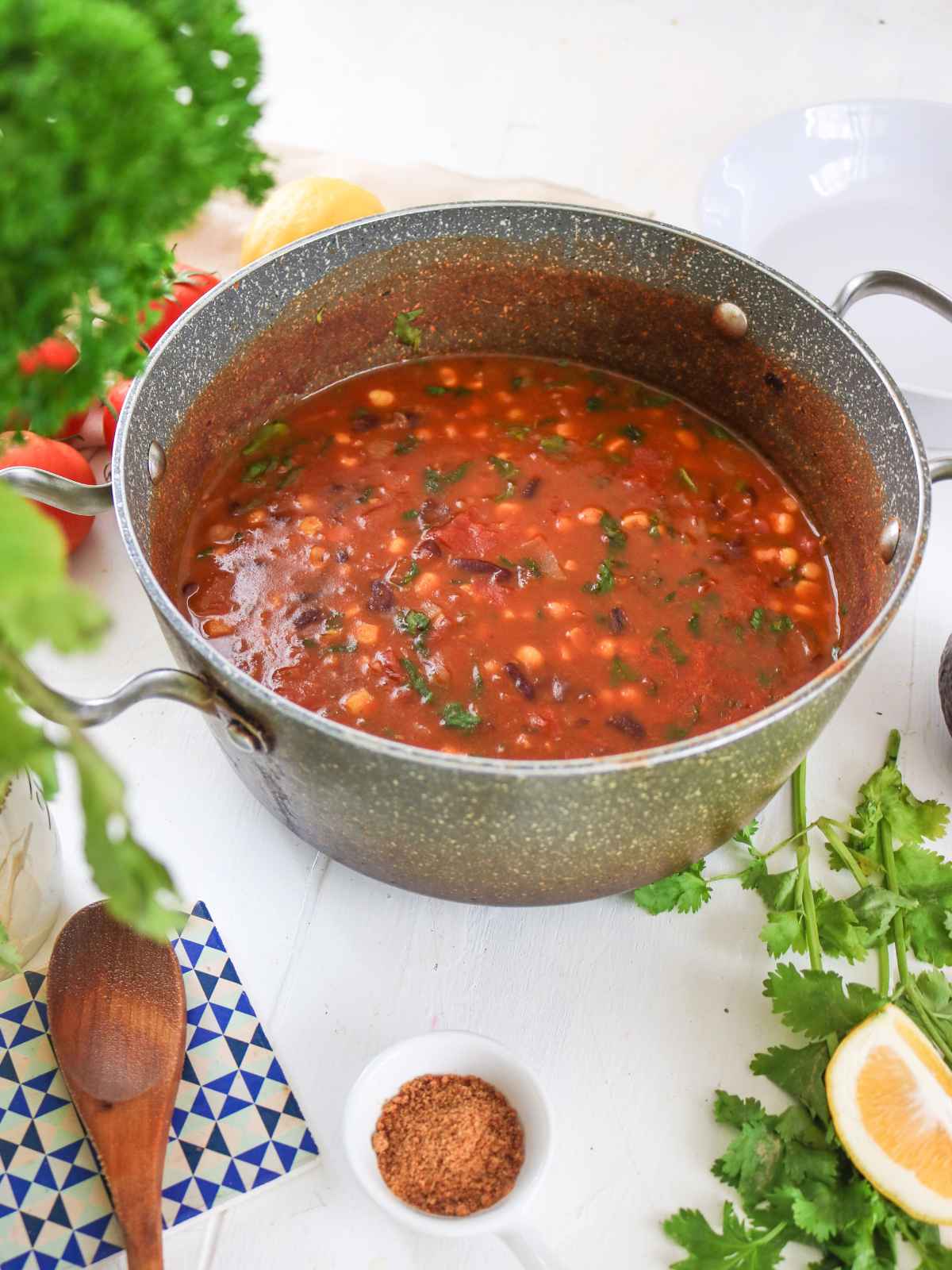 Taco soup in a big metal pot and ingredients on the background.