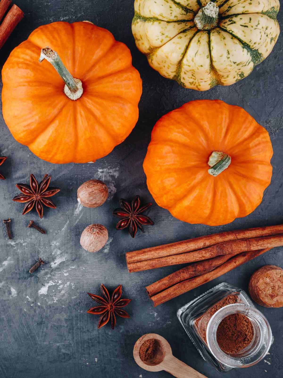 Pumpkin pie spice and orange pumpkin on dark background.