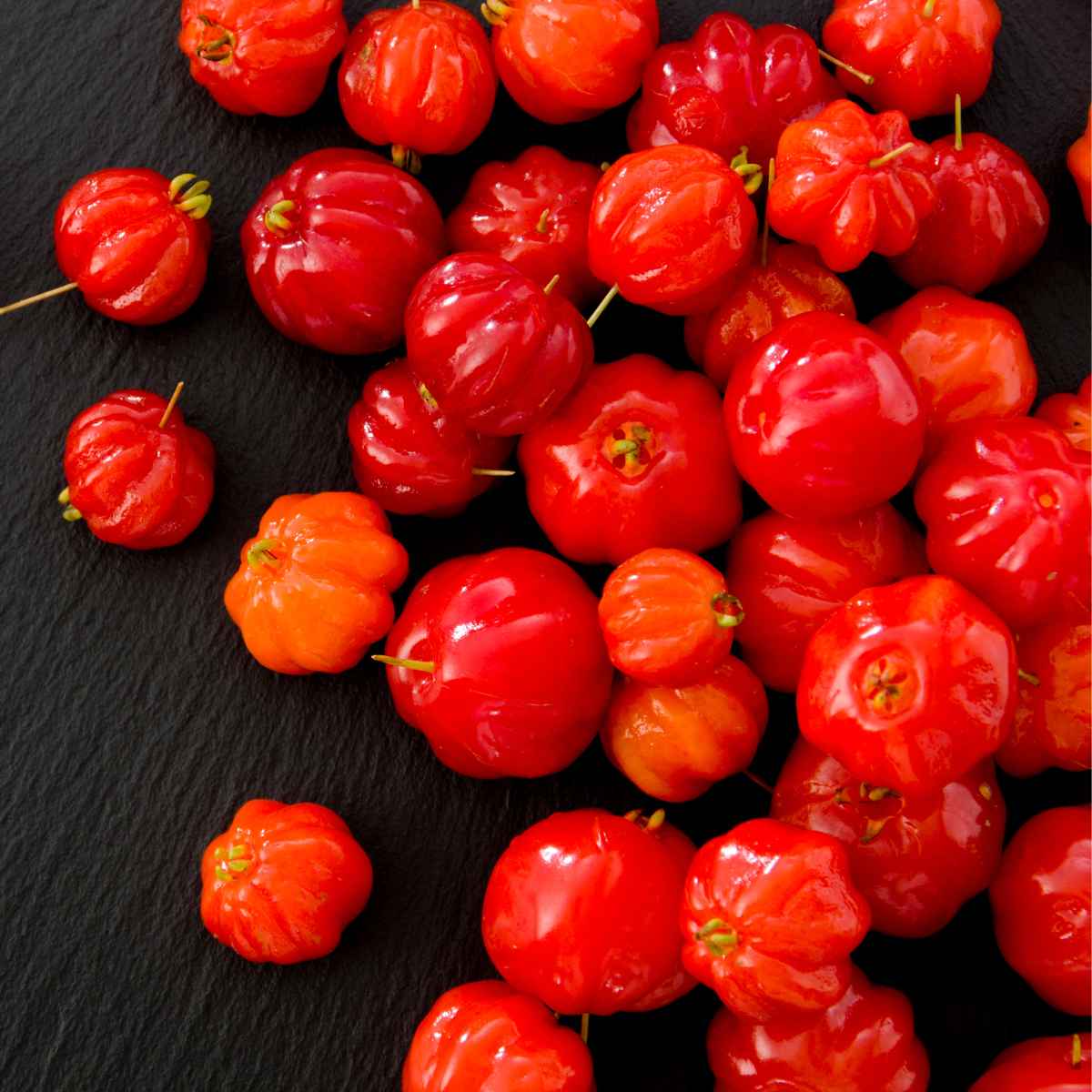 Surinam Cherries placed on a black background.