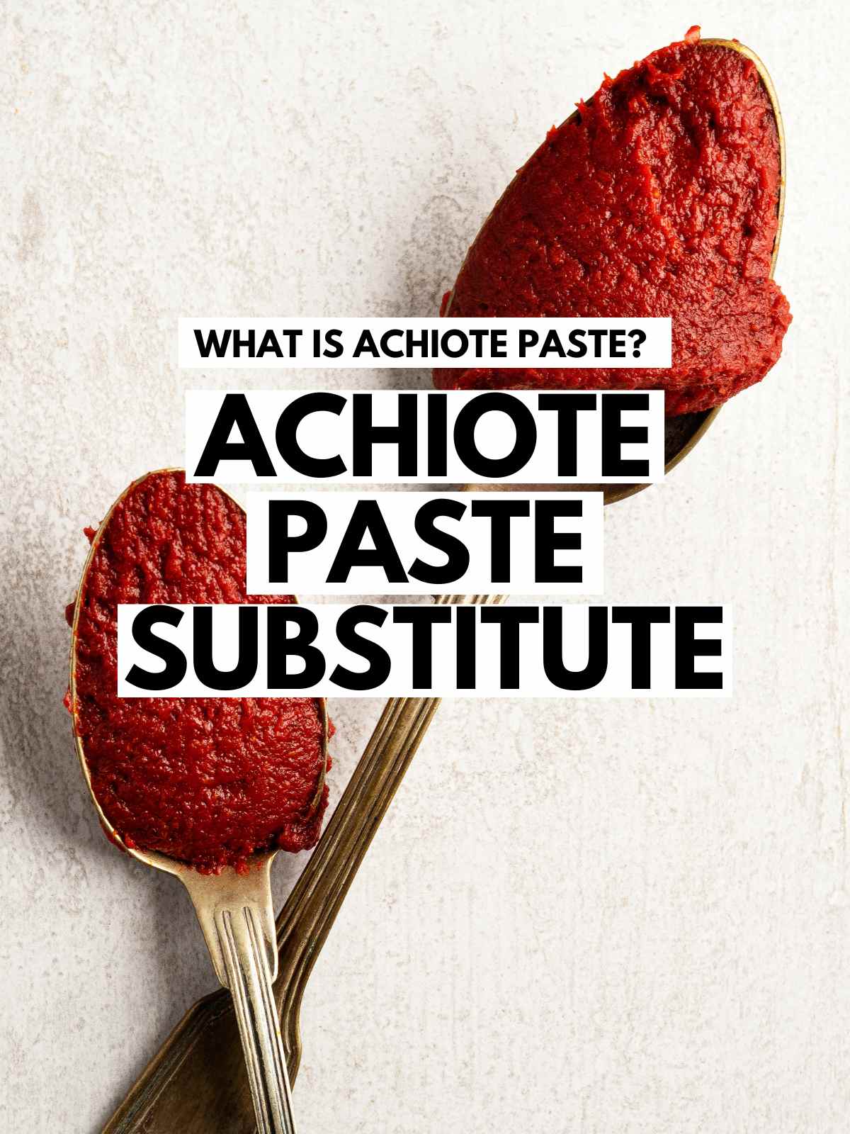 Achiote Paste in two silver spoons placed on a light color background.