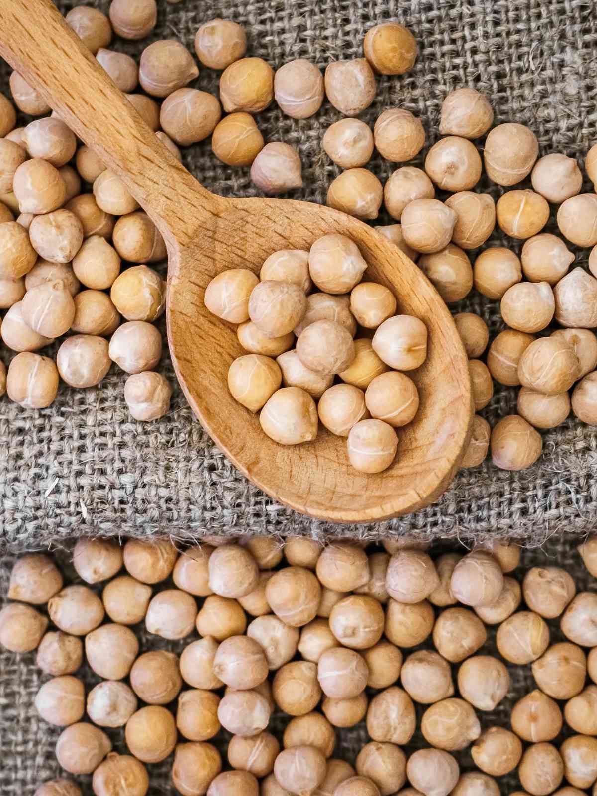 Chickpeas placed on wooden spoon. 