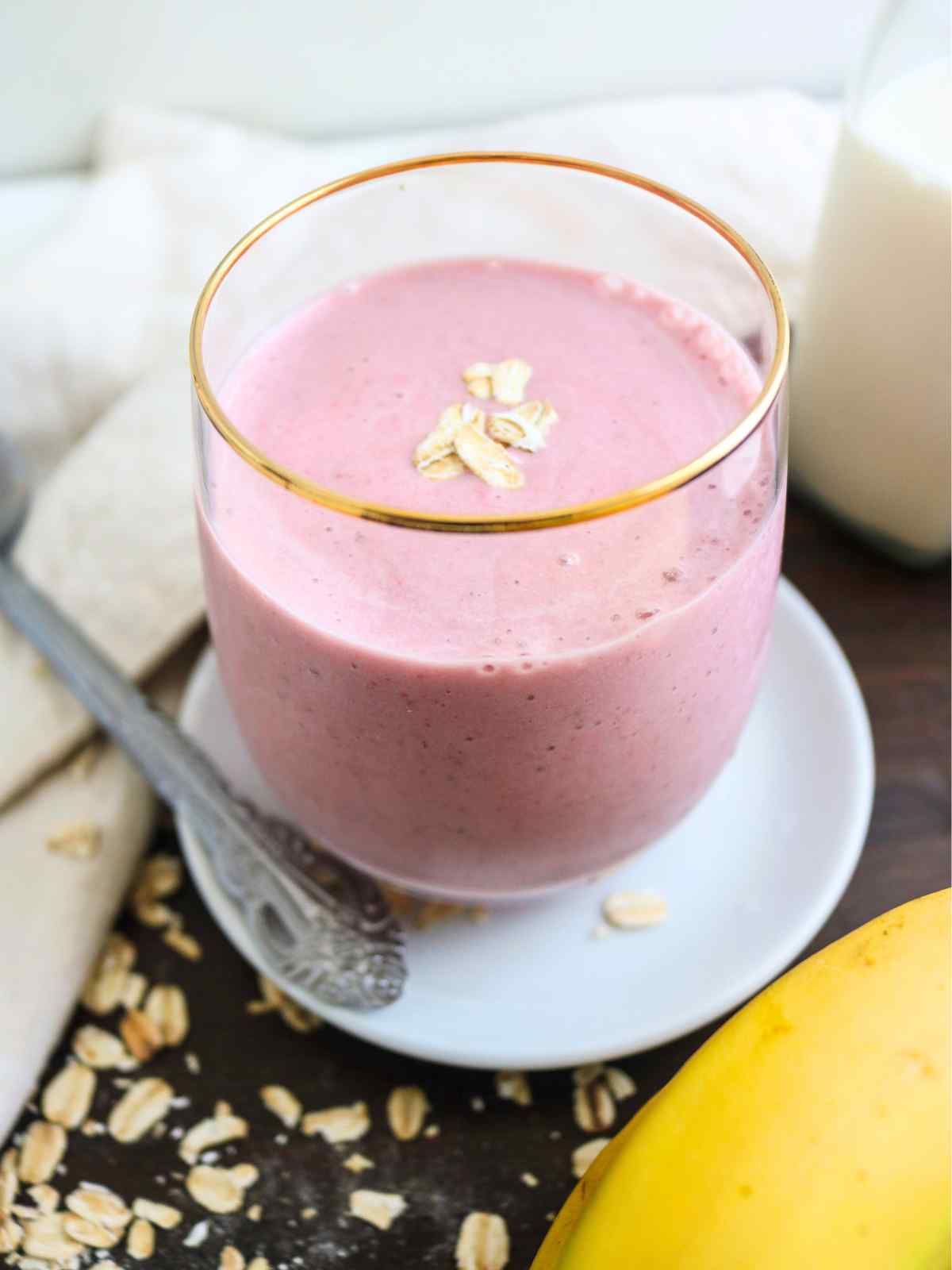 oat milk smoothie in a glass jar topped with some oats.