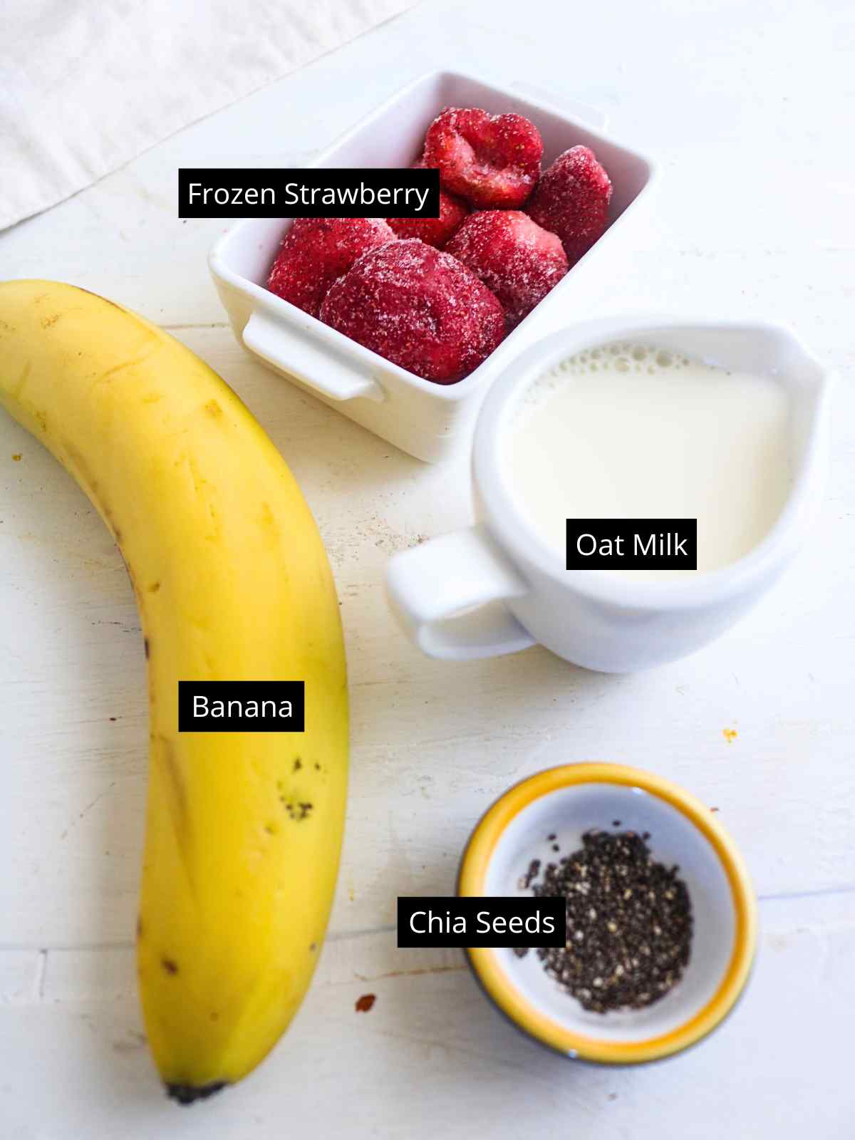 Ingredients placed on a white background to make oat milk smoothie.