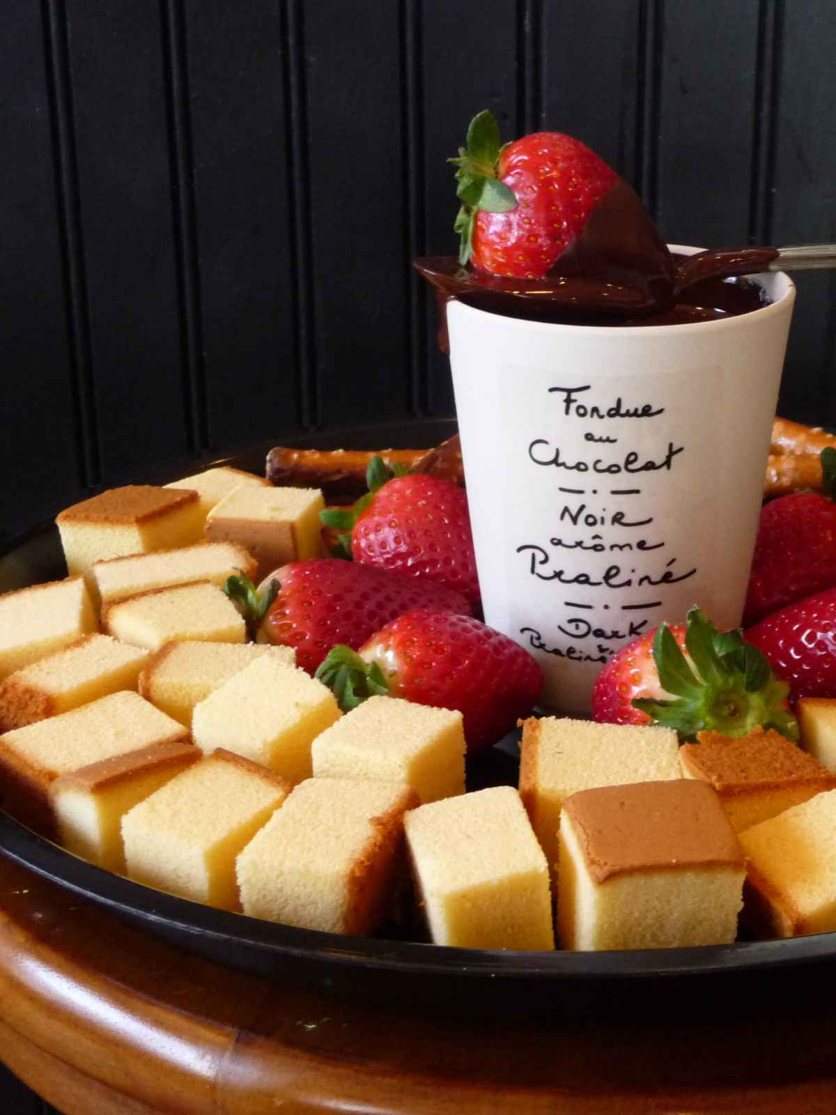 Bite size cake pieces and fresh strawberries served as a dipper with chocolate fondue.