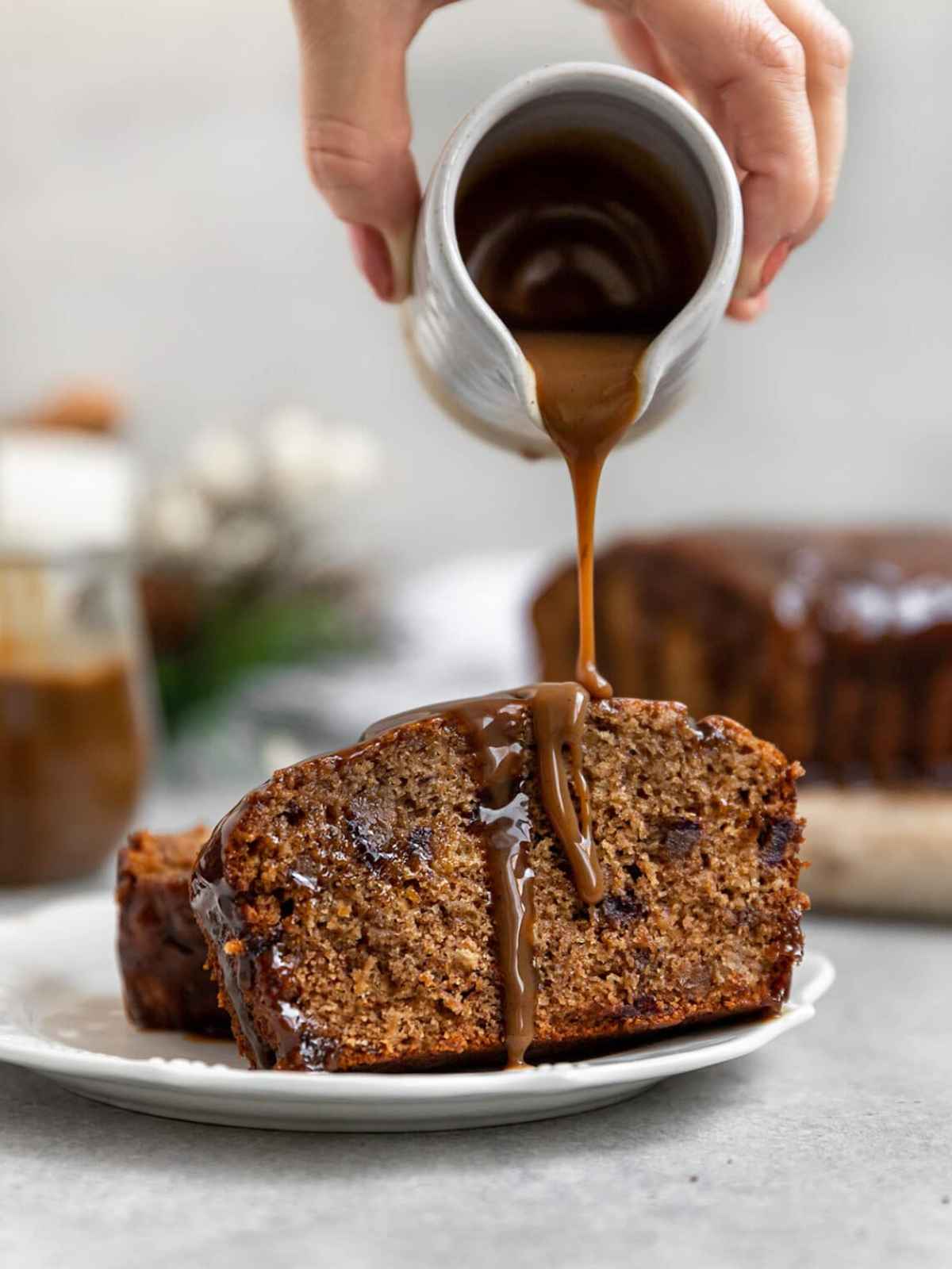 Pouring caramel sauce over date cake.