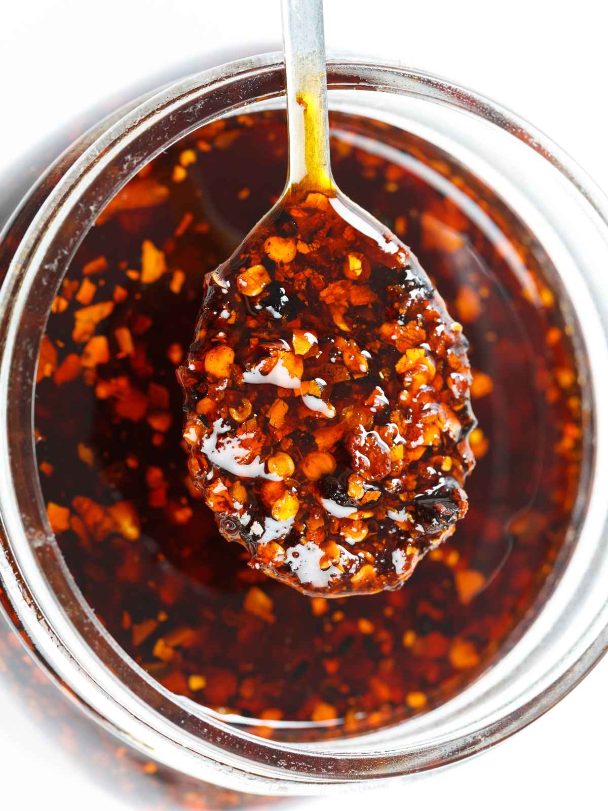 Homemade chili oil in a bottle and spoon.