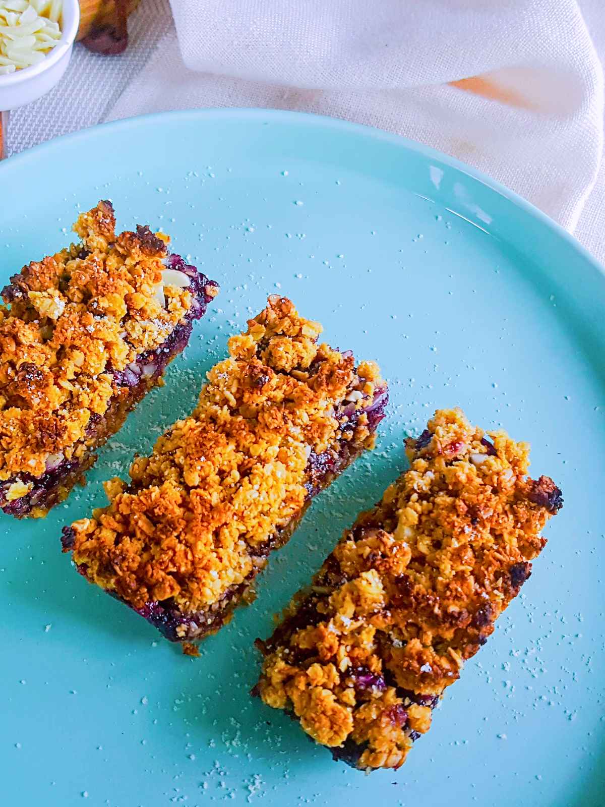 Three slices of jam bars placed in a blue color dish.