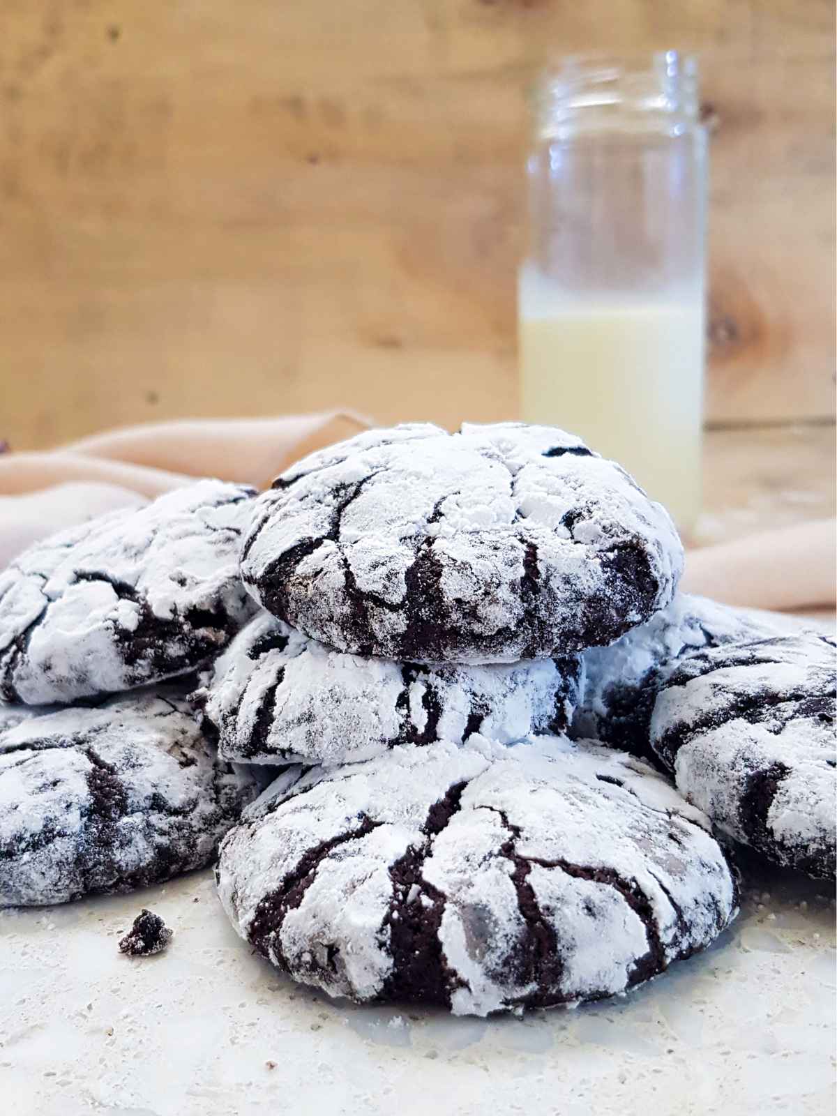 Stack of chocolate crinkle cookies with a glass of soy milk.