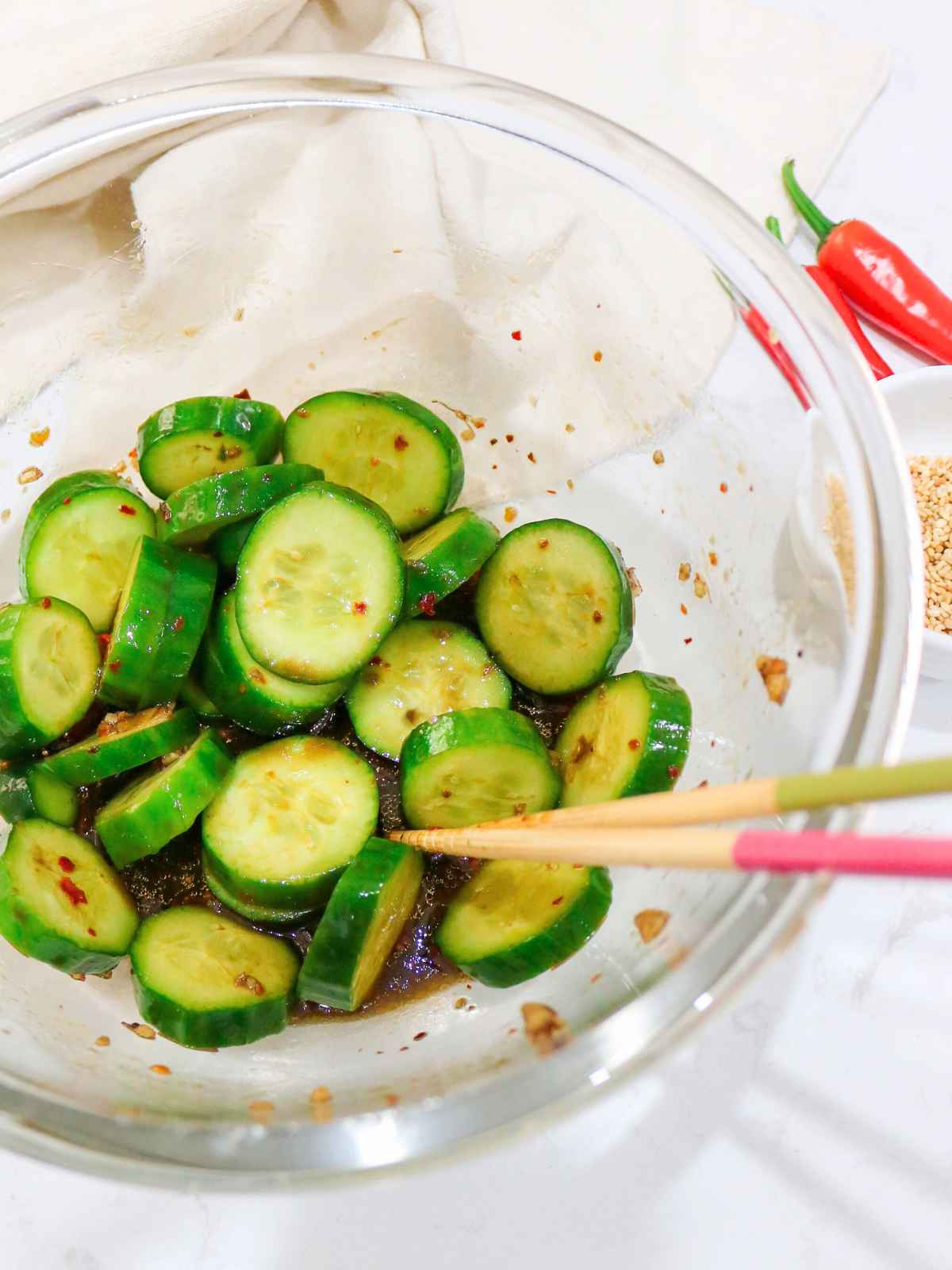 Combining the salad dressing with cucumbers.